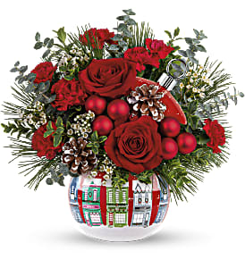 SNOWY VILLAGE BOUQUET - Spread holiday cheer near and far with this charming ceramic ornament jar, adorned with a snowy Christmas village and bursting with holiday blooms.  Red roses, miniature red carnations and white waxflower are accented with white pine, oregonia and seeded eucalyptus. Delivered in Teleflora's Snowy Village Ornament. Approximately 13&quot; W x 12&quot; H