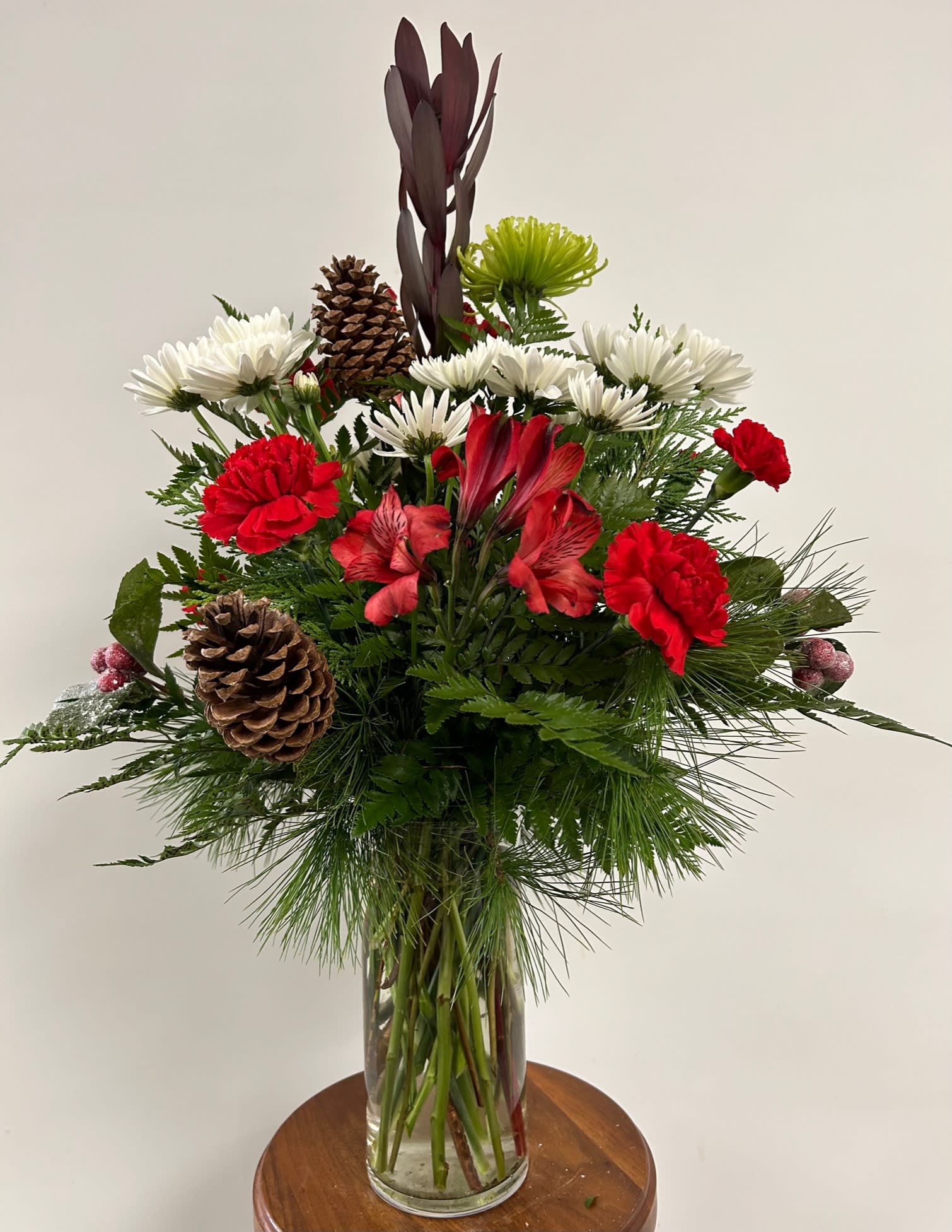Christmas Vase Christmas Vase - Clear glass vase filled with a Christmas mix of flowers and pinecones.
