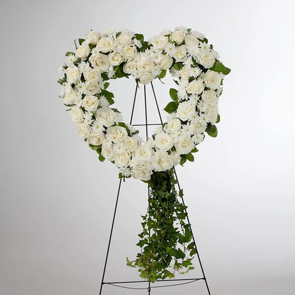 Love in our Hearts - An all white tribute, this heart shaped easel shows your everlasting love. Featuring a variety of white flowers and greenery, this heart with a trail of ivy compliments the beauty of life. 