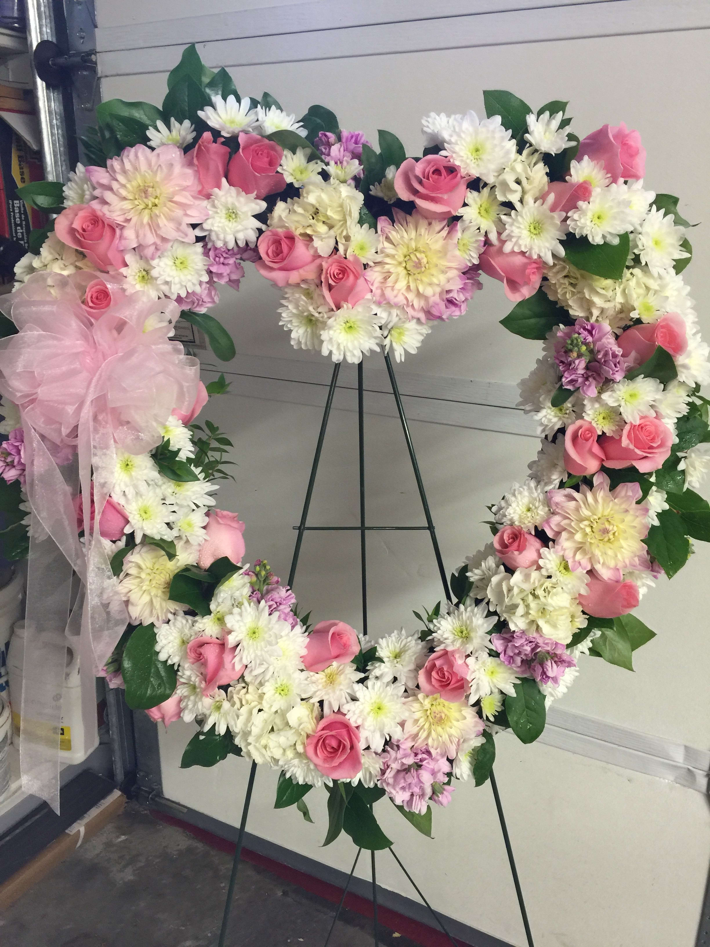 Love Always - To express your love and sympathy-- A heart-shaped easel spray featuring two dozen pink roses mixed with dahlias, mums, and lemon leaf.
