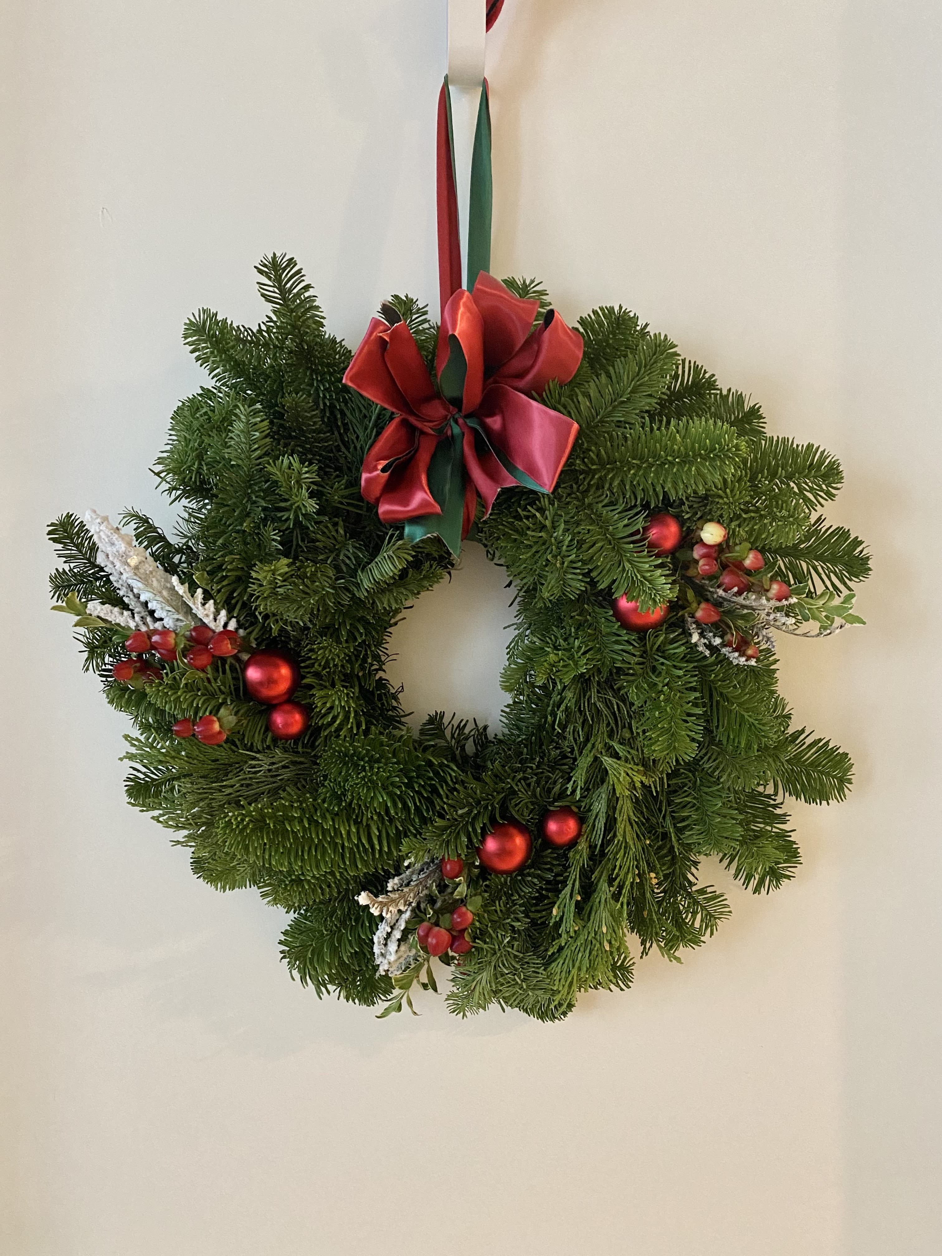 Classic Christmas Wreath - Deck the halls in classic Christmas style! Our traditional wreath is crafted from fresh-cut, fragrant evergreens and accented with red berries. A red and green bow and red point complete the look. 