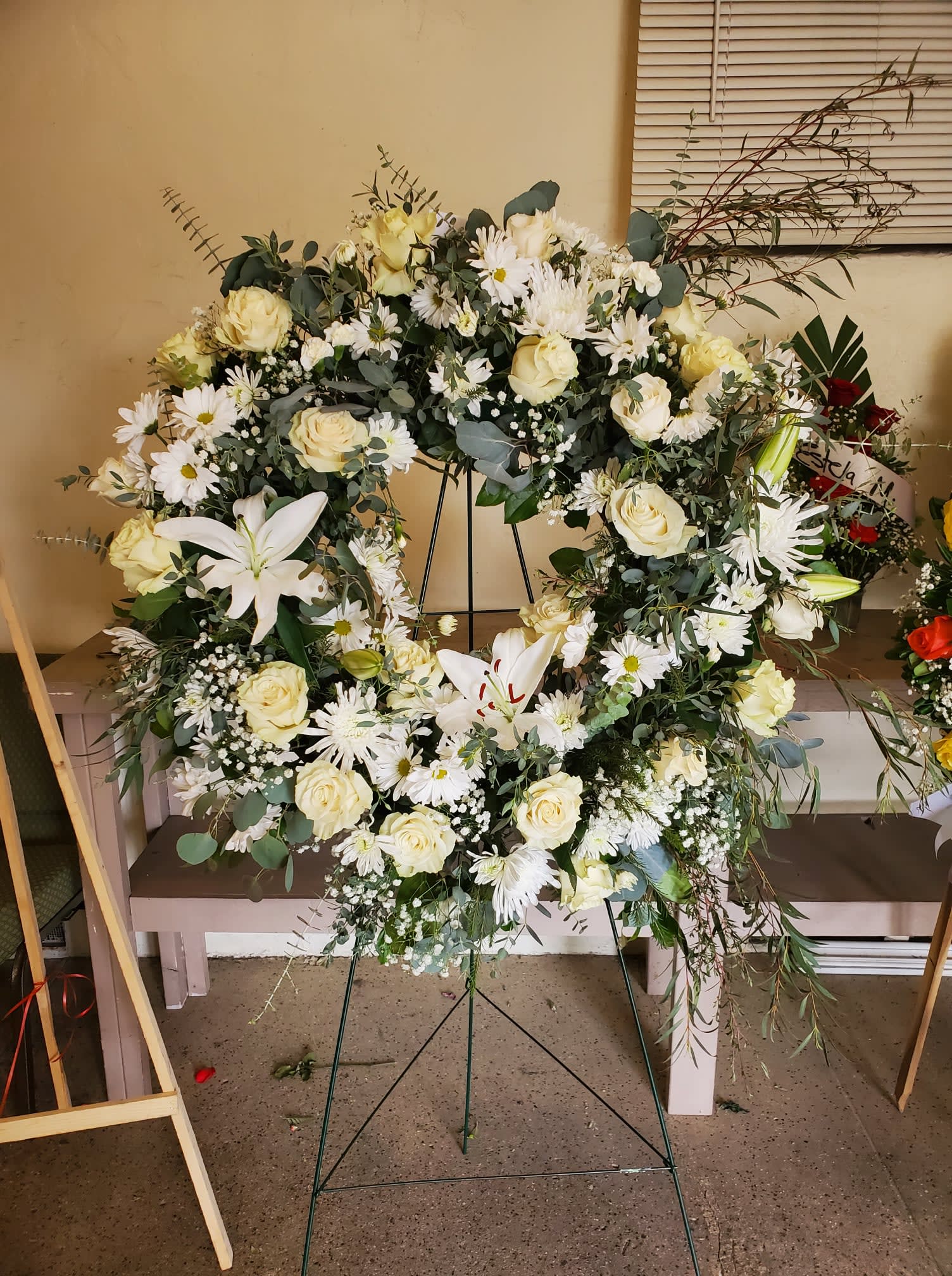 Lasting Serenity by Barrio Logan Florist  - A beautiful white and green tribute wreath that calms, this easel arrangement celebrates a full life and a peaceful passing. 