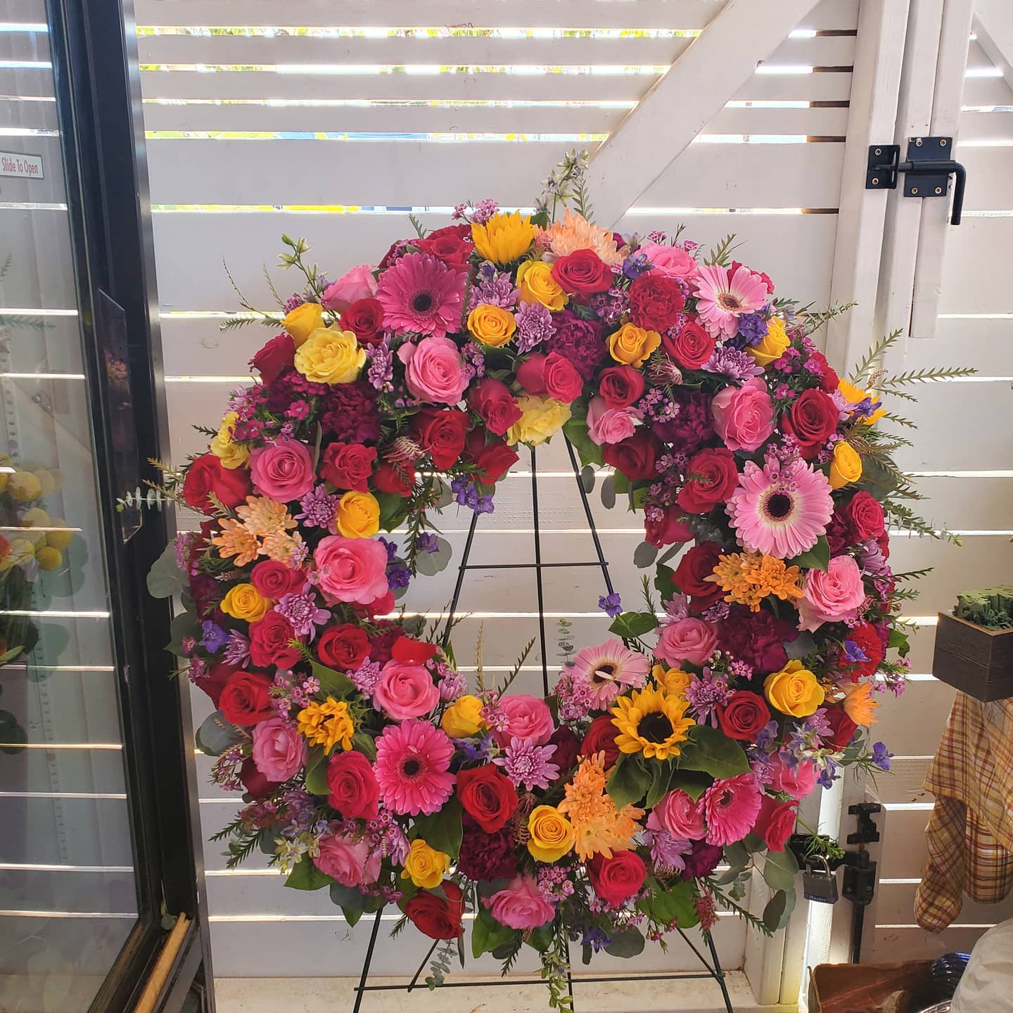 Vivid Spring by Barrio Logan Florist  - This colorful and bright wreath spray is representative of a life lived to its fullest. Colors and Flowers may change based off of season and availability. 