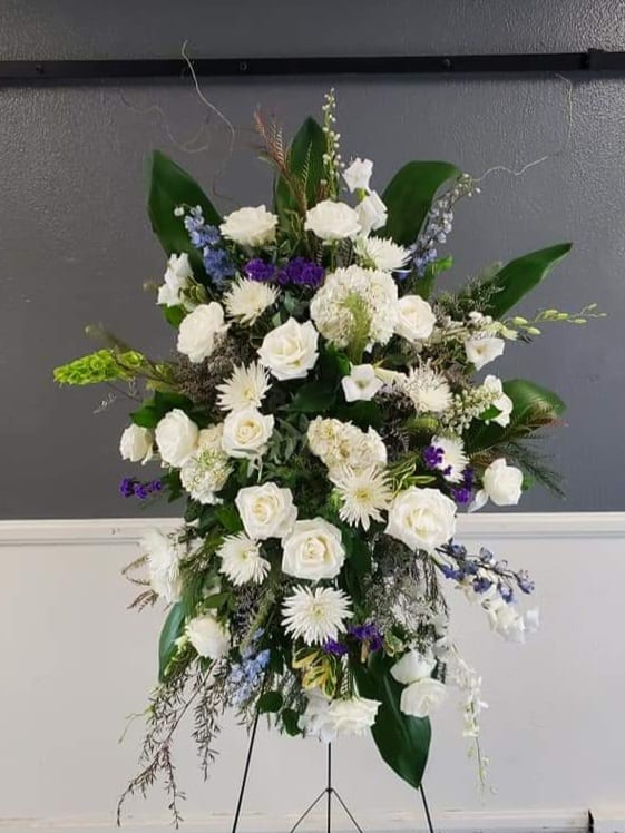 Tribute of Love in White By Barrio Logan Florist  - A beautiful tribute standing wreath piece and a way to frame a wonderful memory. Honor the memories by   