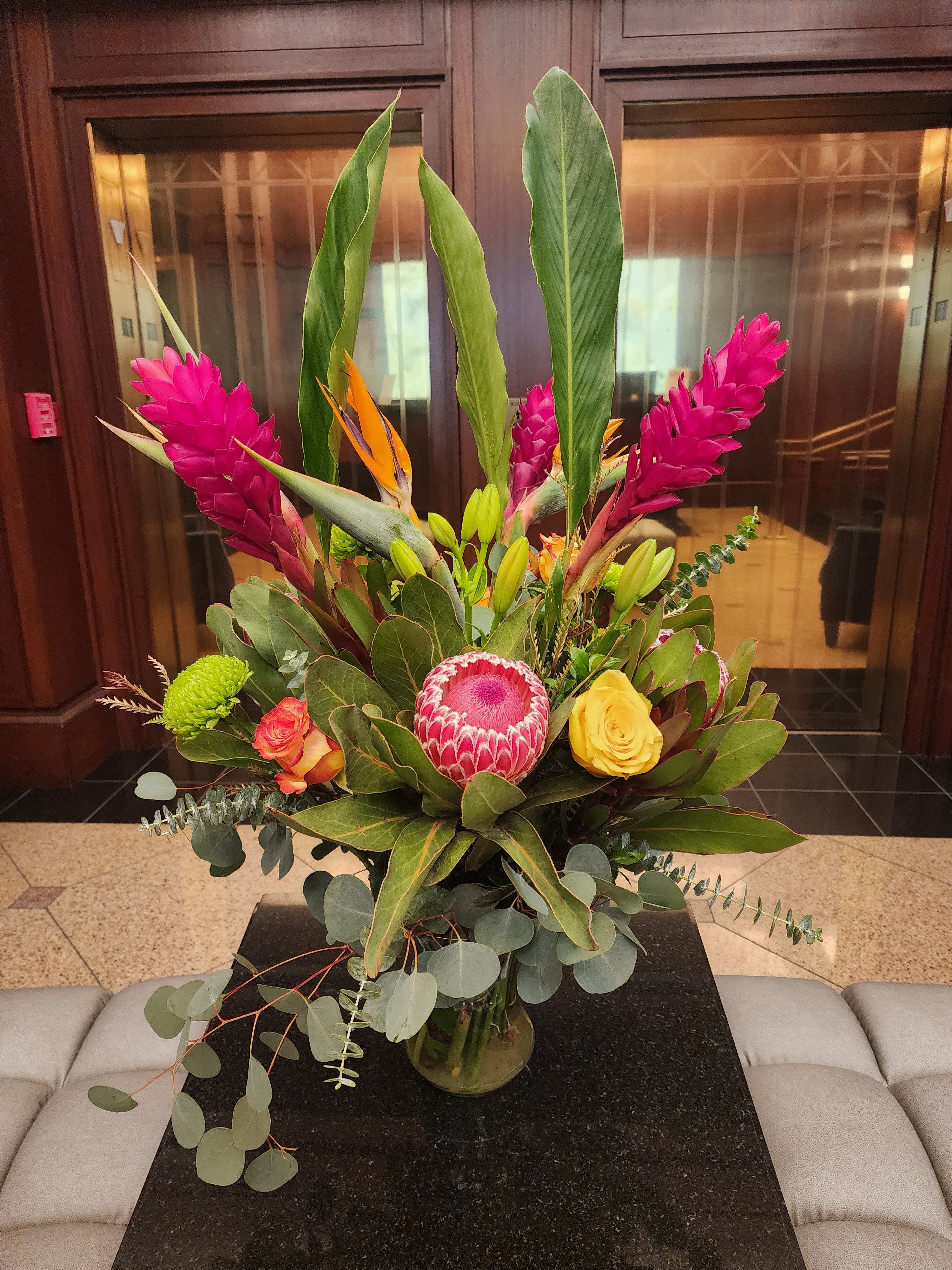 Tropic Like It's Hot by Barrio Logan Florist  - Tropical plants come together in this one-sided tall standing arrangement. Featuring birds of paradise, ginger, and pincushion protea, this tropical selection would look lovely in any home.  Approximate Dimensions: 22&quot;D x 30&quot;H