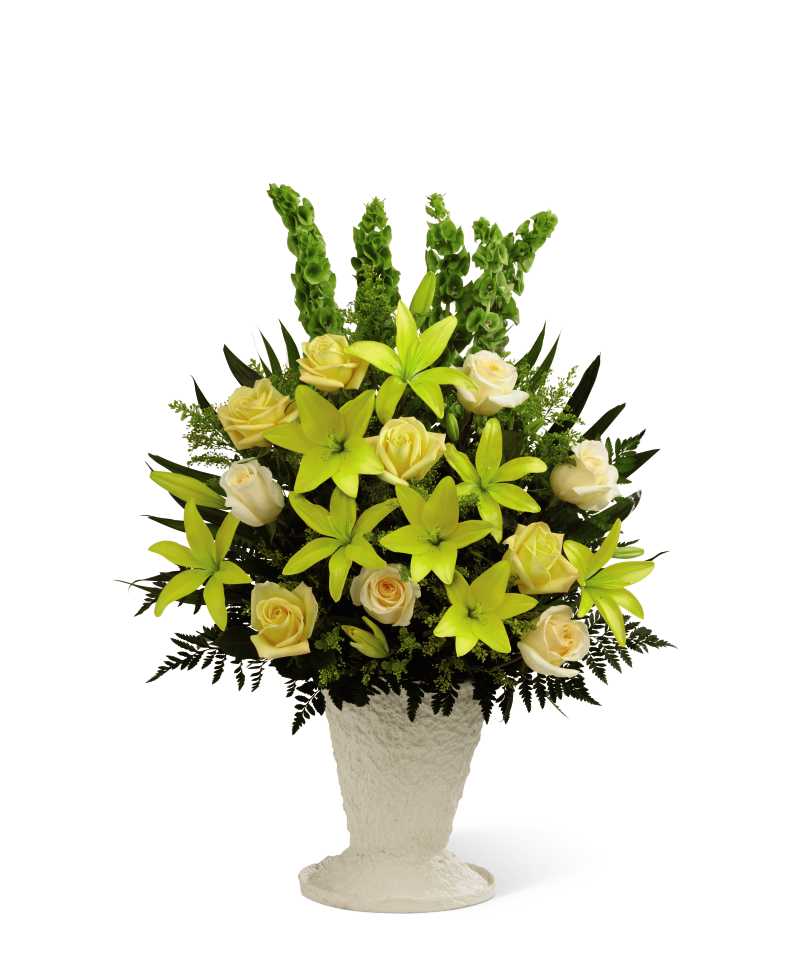 Golden Memories Arrangement - The Golden Memories Arrangement bursts with sunlit beauty to honor the life of the deceased. Brilliant yellow Asiatic lilies, roses and solidago are offset by cream roses, Bells of Ireland, teepee palm fronds and lush greens to create a dazzling display. Arranged in a white mache urn, this incredible presentation of floral grace will bring a cheerful elegance to their final farewell service.