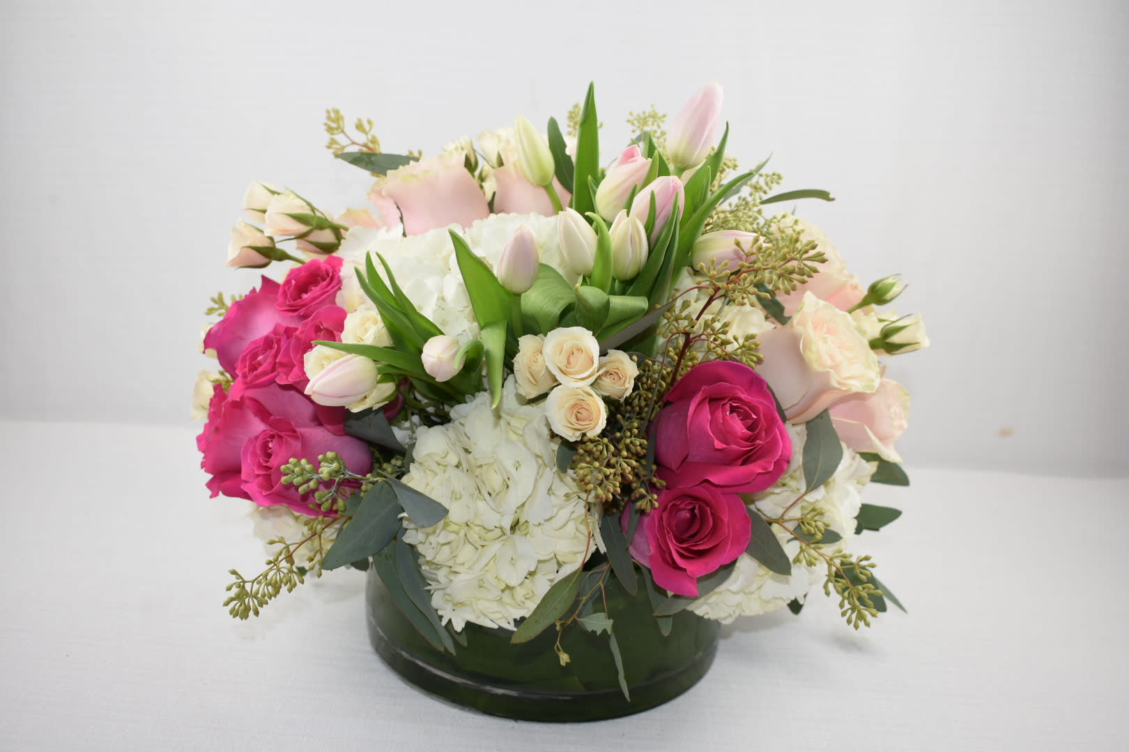 Pink petals  - round low glass vace  perfectly arranged with some pink shades Ecuadorian roses combined with white hydrangeas and tulips and spray roses  definitely perfect for any occasion 