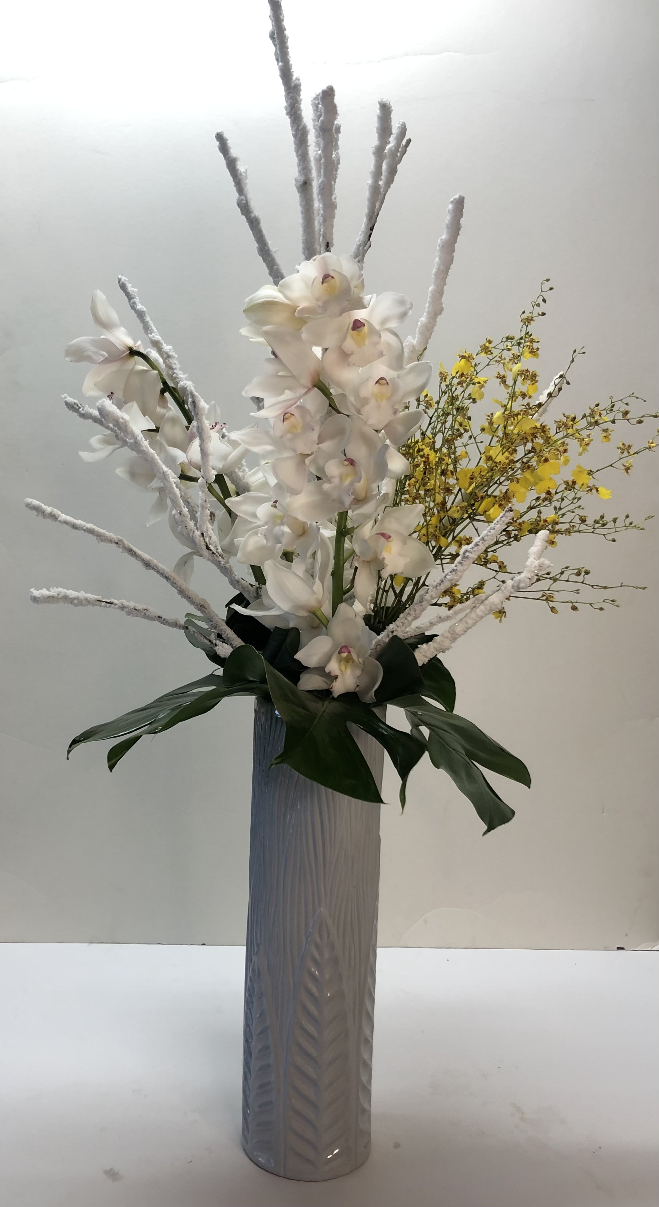 Winter #EF208 - Tall ceramic cylinder with Snow Stikes,  Fresh Cut White Cymbidium Orchid &amp; Yellow Oncydium Orchids &amp; Monstera Leafs