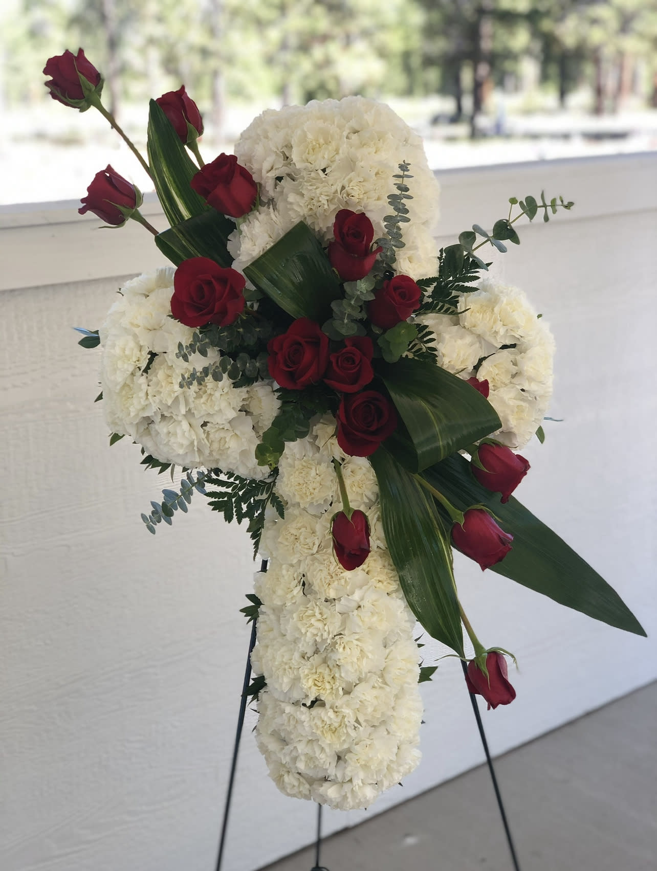 White Cross Standing Spray - Commemorate fidelity with this standing spray cross of white blossoms and red roses. It’s a display that remembers faith, hope and charity. 