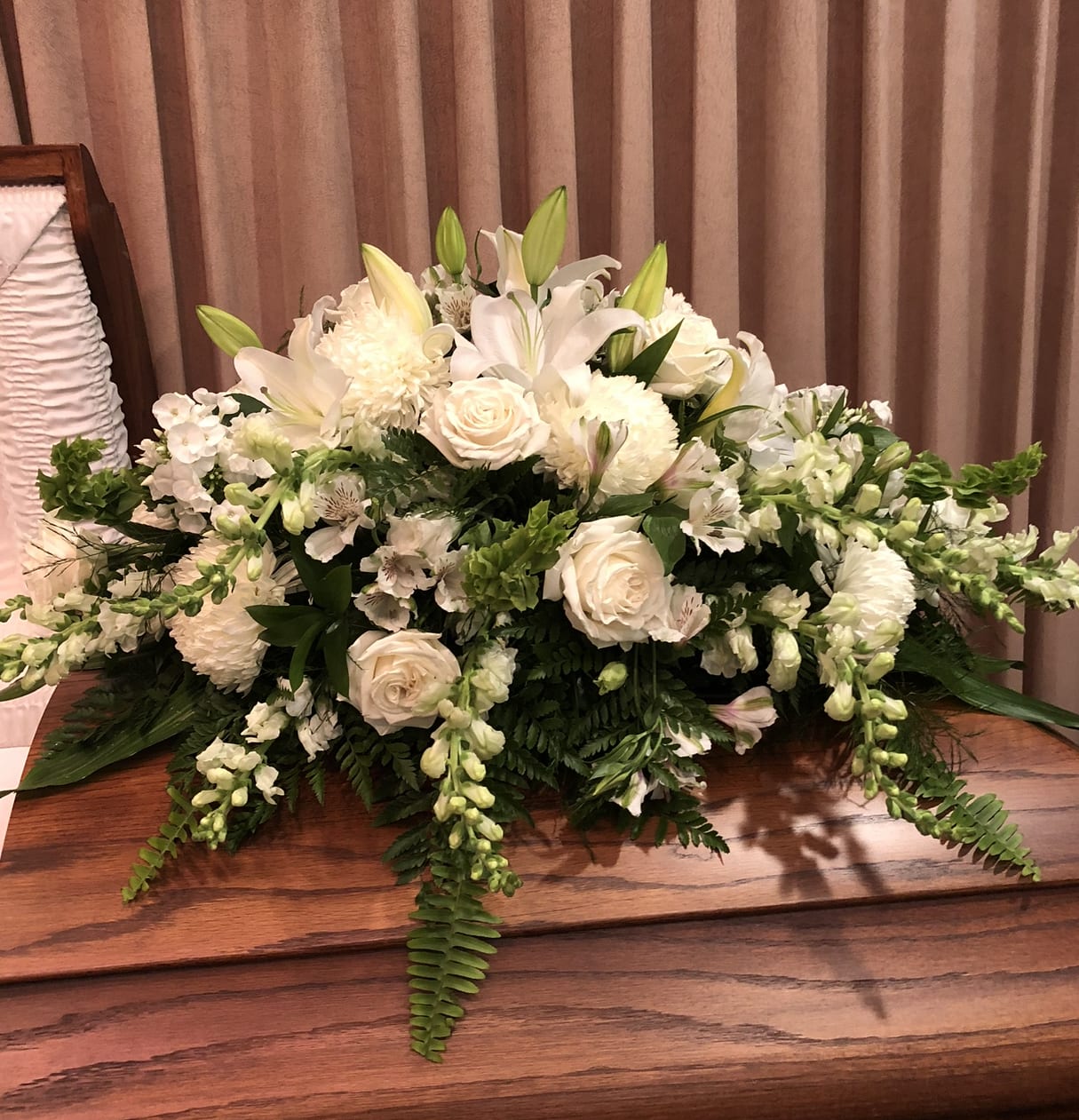All White Casket Spray - Show purity of love with a mix of all-white flowers that’s as gentle and pure as a cloud. Accented with a mix of greenery, fragrant white flowers create a lovely and traditional casket spray.