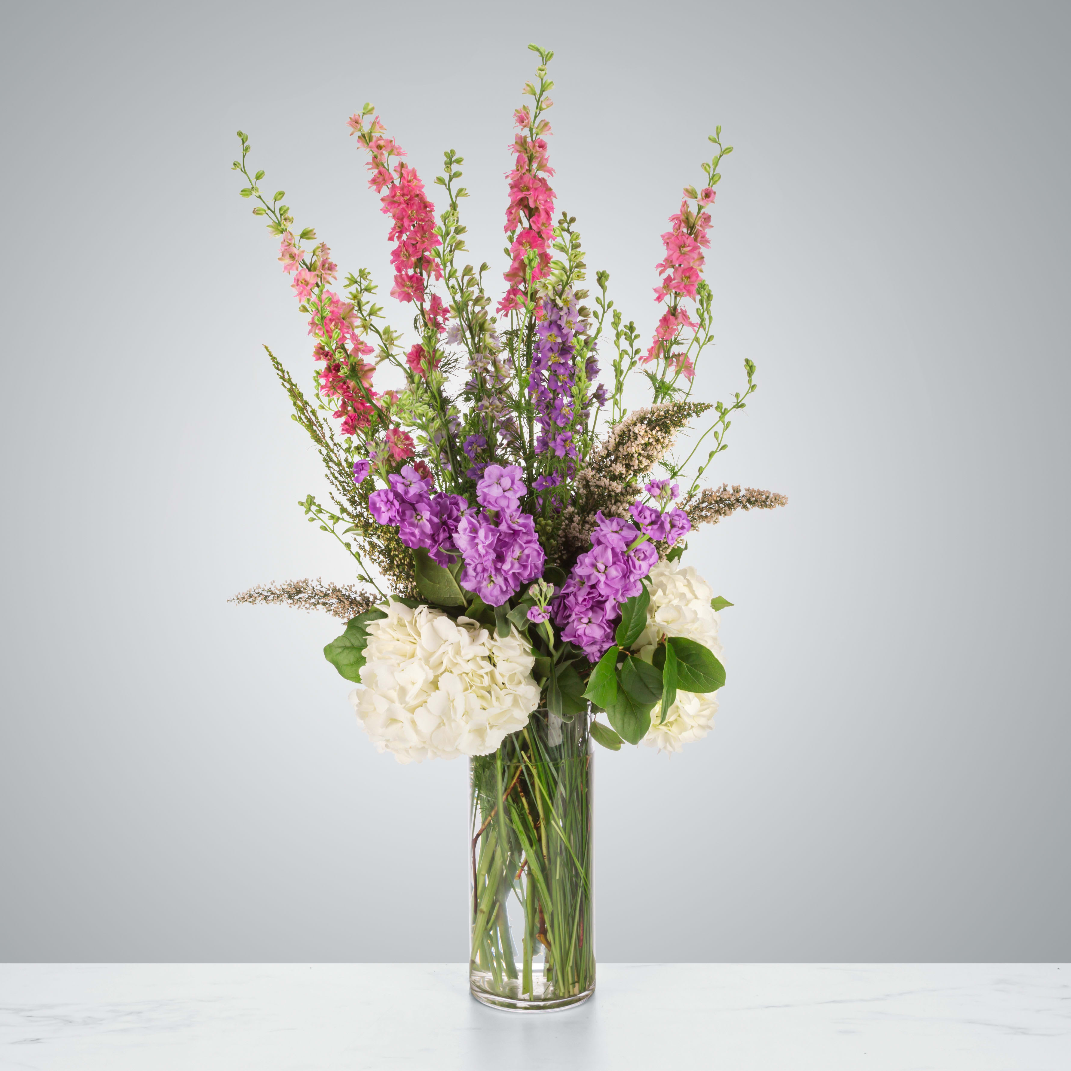 Heather Garden by BloomNation™ - Standing tall, this arrangement is a gardener's dream. Perfect for people who like that wildflower look, Heather Garden by BloomNation™ features heather, larkspur, hydrangeas, and more.  Approximate Dimensions: 12&quot;D x 30&quot;H