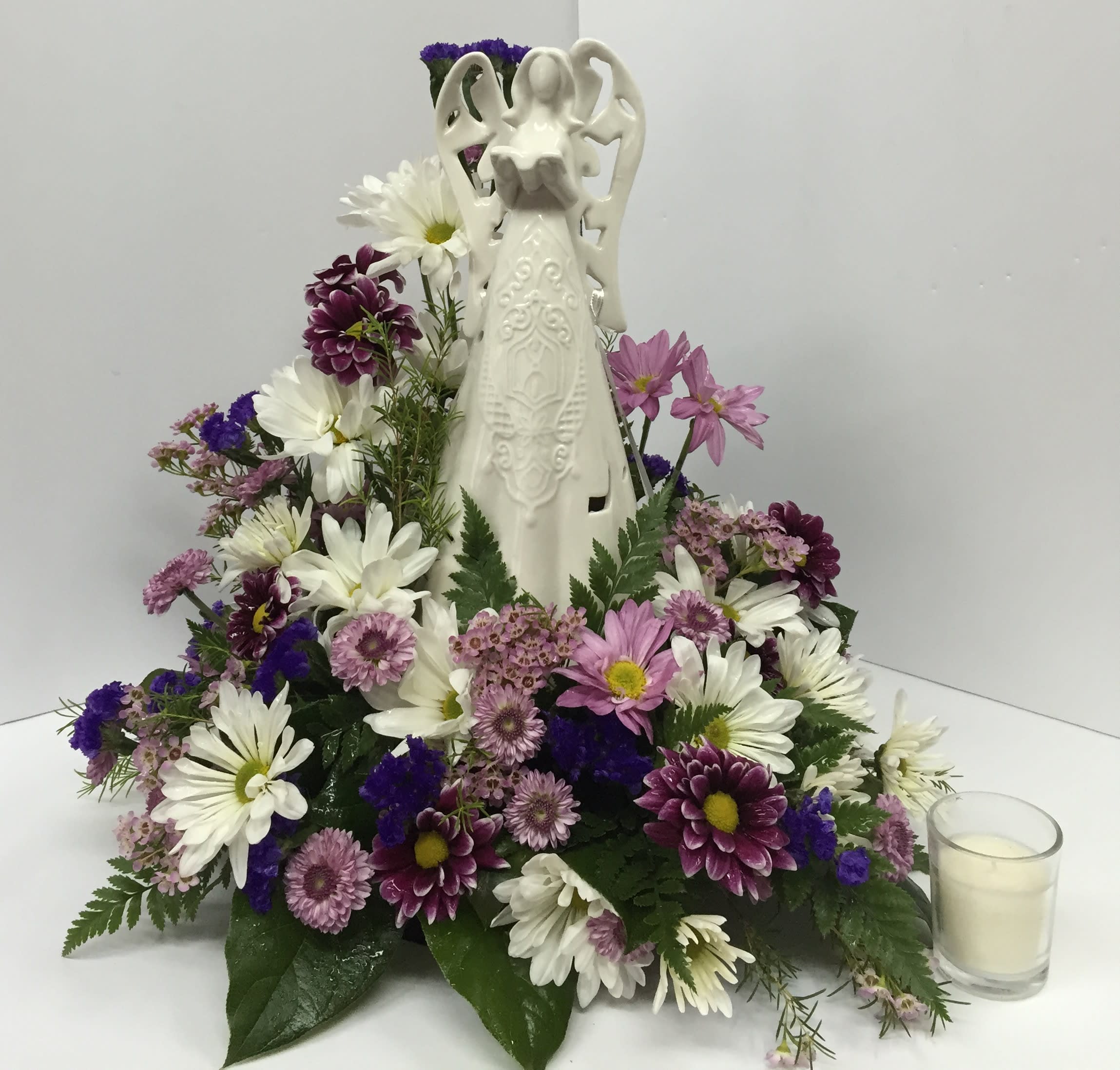 Angelic Light - 10&quot; Lighted Ceramic Angel nestled in a lovely bouquet of lavender and white daisies, lavender button mums, purple status, purple chrysanthemum daisies and lavender wax flower.