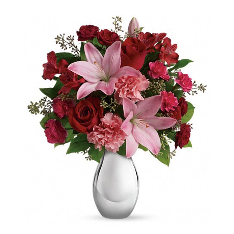 Teleflora's Moonlight Kiss Bouquet - She'll feel the love when she receives this gorgeous array of roses, lilies and more artistically arranged in a dazzling silver reflections vase. You'll also feel the love when she finishes oohing and aahing and turns to thank you.  This romantic bouquet includes red roses, red spray roses, pink asiatic lilies, red alstroemeria, pink carnations and pink miniature carnations accented with assorted greenery. Delivered in a silver reflections vase.  Approximately 14 1/2&quot; W x 17 1/2&quot; H      Orientation: One-Sided      All prices in USD ($)      Standard      T409-1A      Deluxe      T409-1B      Premium      T409-1C 