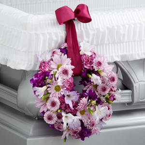 The FTD Thoughts &amp; Prayers Wreath Adornment - The FTD® Thoughts &amp; Prayers™ Wreath Adornment is a sweet accent to symbolize your love and affection for the deceased. Lavender carnations freesia daisies and button poms are accented with deep magenta stock and arranged to form a 6-inch wreath which hangs from the side of the casket from a burgundy wired ribbon.