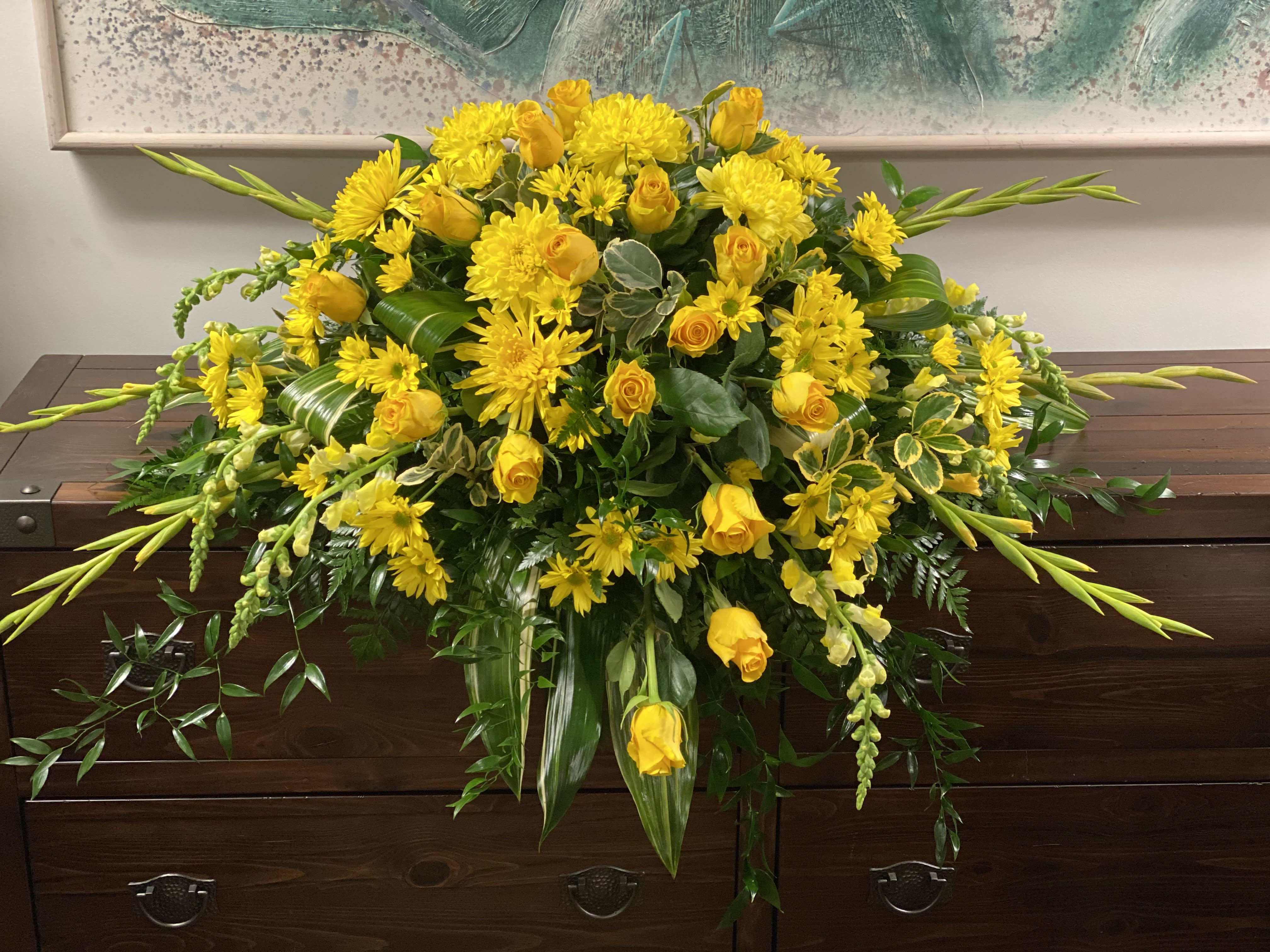 Graceful Grandeur Casket Spray Graceful Grandeur Casket Spray - Joyous times and golden memories are recalled with this lovely half-couch casket spray that consoles the bereaved with a sunny array of beautiful blooms.