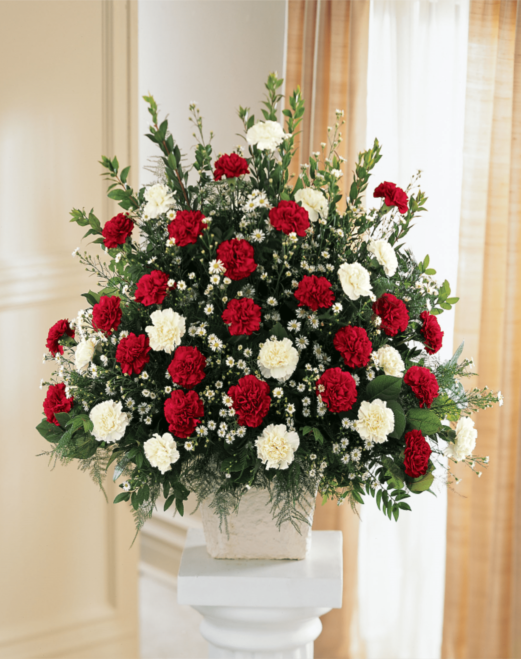 Devotion Arrangement - Red carnations and white carnations are accented with white monte casino in this traditional arrangement. A variety of greens adds texture and fullness to the design. ******This can be done in any color combination. Pink and white, yellow and white . etc. Call for choices.************A one-sided composition, this is appropriate to send to the funeral home or service. 