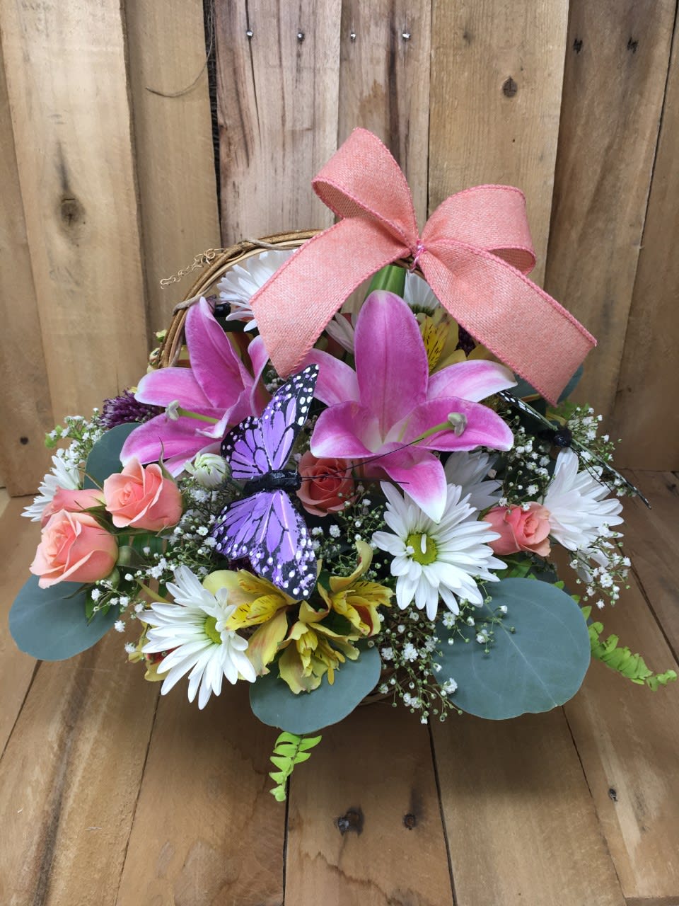 Spring Basket of Fresh Flowers - If you love Spring, this basket is perfect for you. This natural wicker basket is filled with fragrant lilies, miniature roses, daisies, alstroemerias, babies breath and greens. The ribbon and butterfly are the perfect spring accents to finish this bouquet.