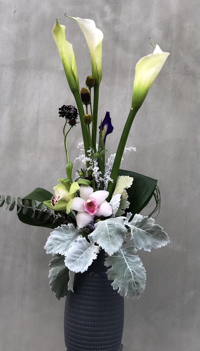 Distinctive Aroma Distinctive Aroma - White Calla Lilies, Cymbidium orchids, dusty miller, eucalyptus, ti leaves, etc all hand arranged in Glass vase.