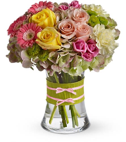 Fashionista Blooms - This arrangement would be perfect for any girl with an eye for style. It's a must-have for fashionistas everywhere. Gorgeous green hydrangea yellow and light pink roses pink spray roses and mini gerberas light yellow carnations and green button spray chrysanthemums are delivered in a pretty gathering vase. Not just any vase of course this one's accessorized with a chartreuse taffeta ribbon and pink raffia.Approximately 10&quot; W x 11&quot; H Orientation: All-Around As Shown : T155-1ADeluxe : T155-1BPremium : T155-1C