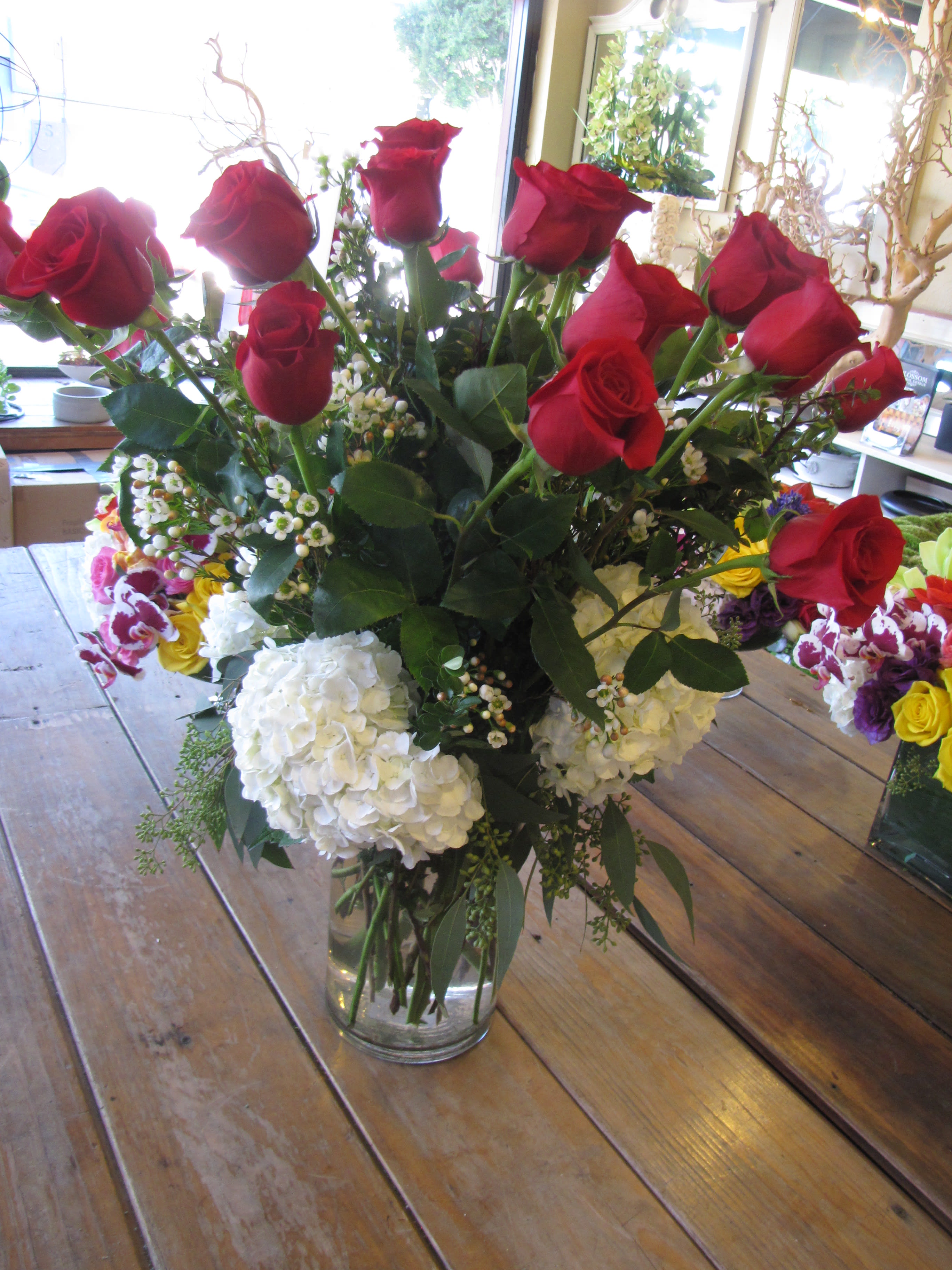 Two Dz. Red Roses Two Dz. Red Roses - Two dz. long stem red roses in a clear vase with fillers, decorated with white hydrangeas.