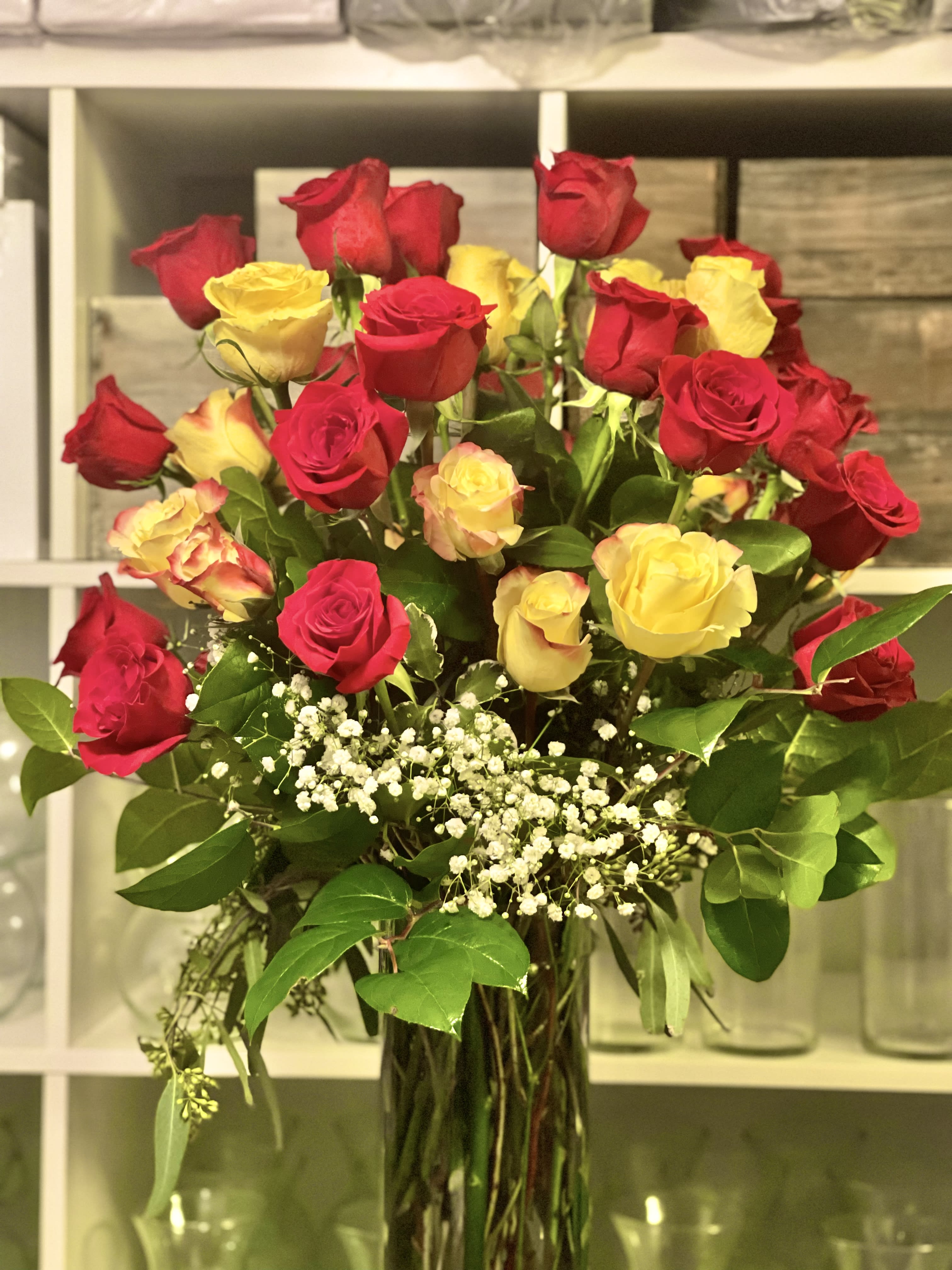 Sky high - Mixed roses with babies breath and lush greens in a tall cylinder vase