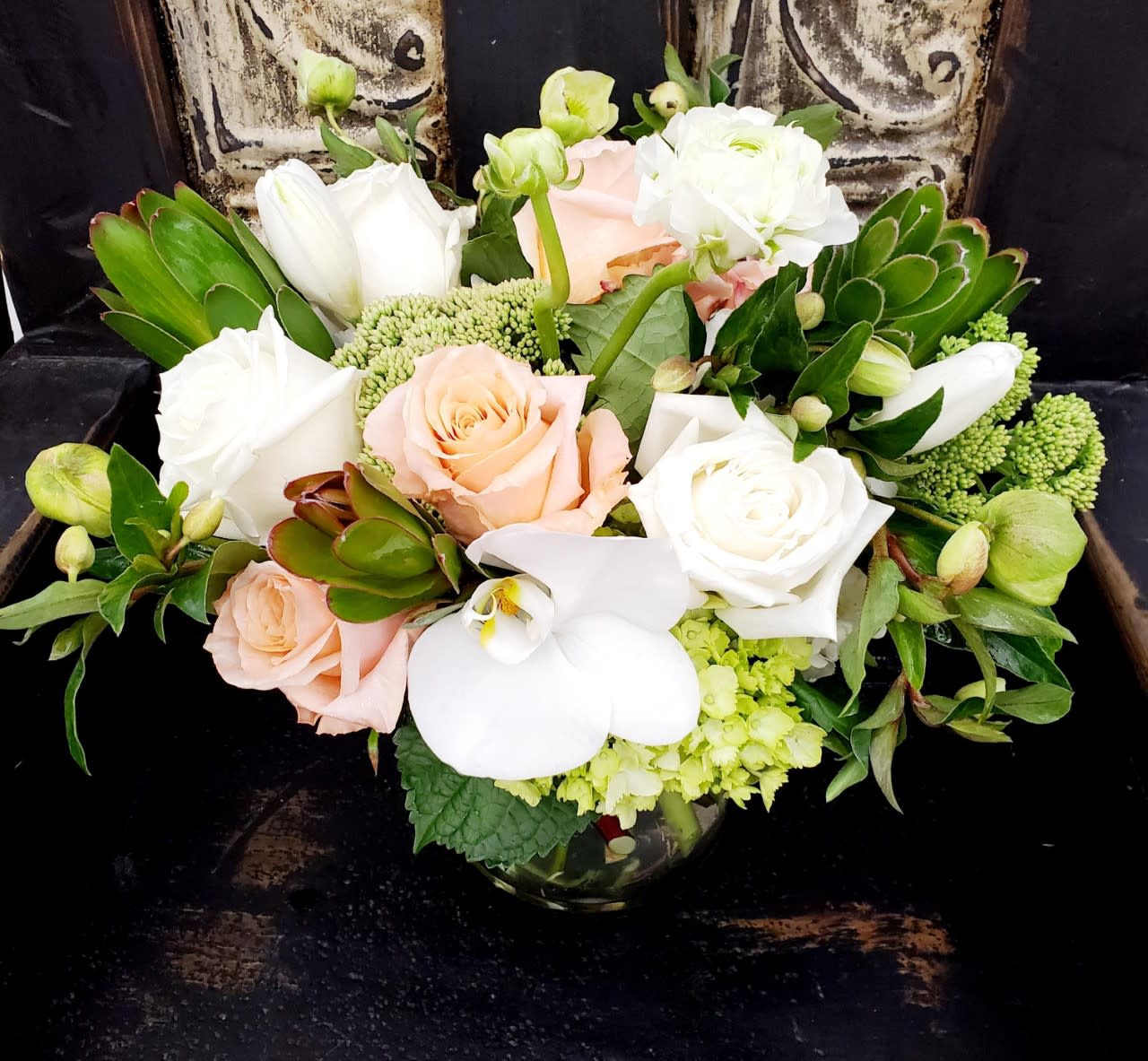 Salt of the Earth Salt of the Earth - Tranquil, relaxing, calming. This arrangement is the perfect peaceful design that give happiness and comfort for any occasion. Includes, Orchids, Garden Roses, hydrangea, ranunculus and more.