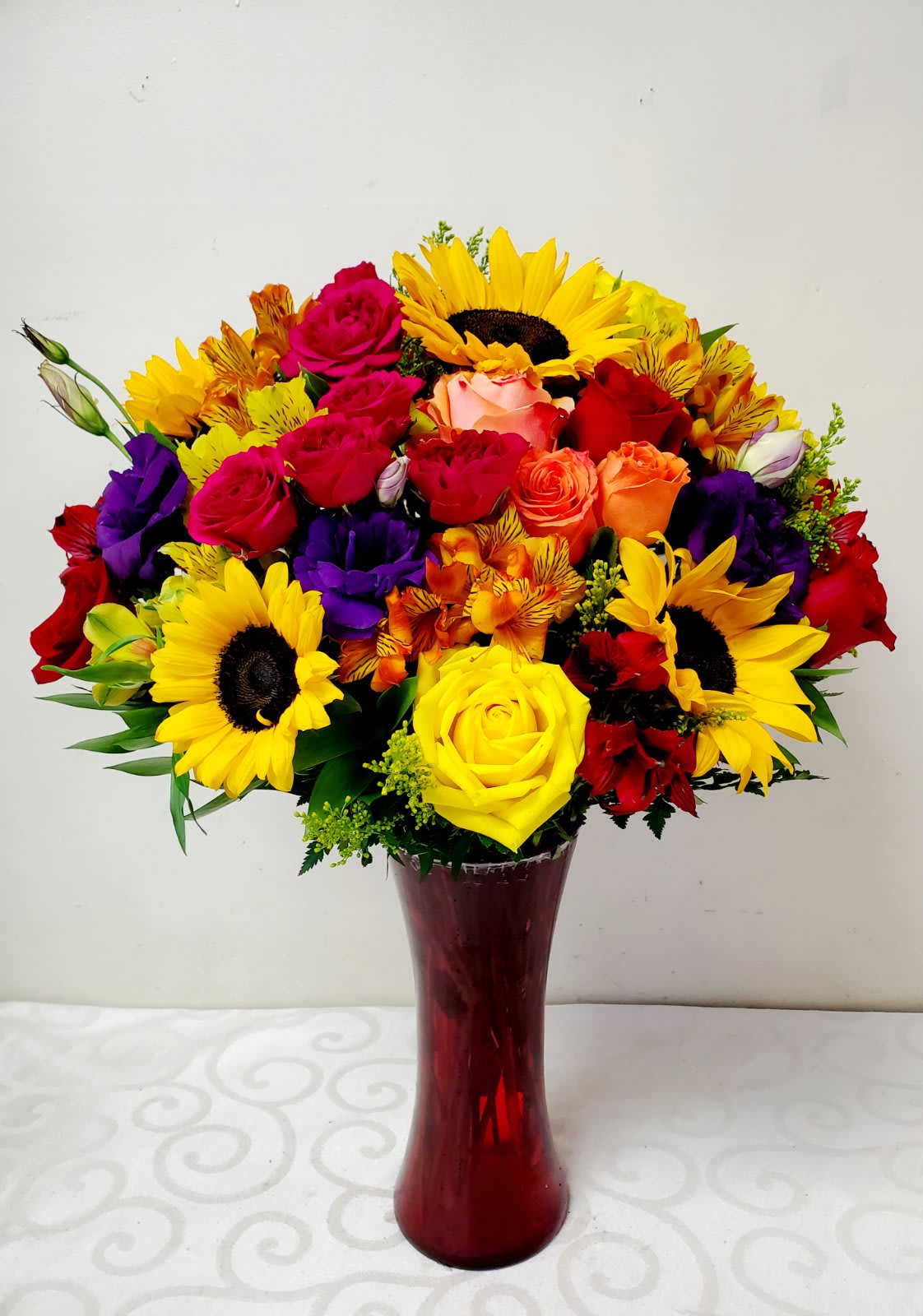 My Bright Light - A colorful medley of flowers expertly handcrafted to pure art and elegance. The beauty of Sunflowers complimented by roses, never fails. Send this to the special someone who brightens your life.  25&quot;H by 18&quot;W