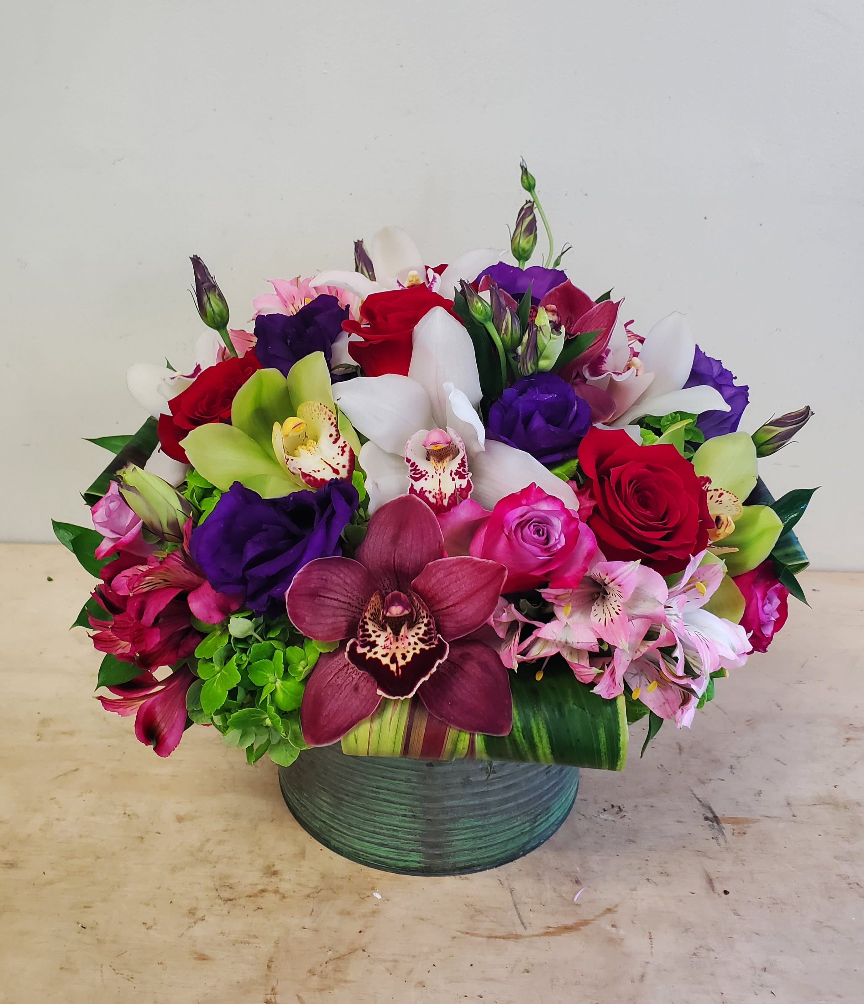 Magical Life Bouquet - Hand crafted bouquet of vibrant fresh orchids, roses, green hydrengea, lysianthus and multi color alstromerias accented with exotic leaves.  Sure to brighten the day of a special someone you love.