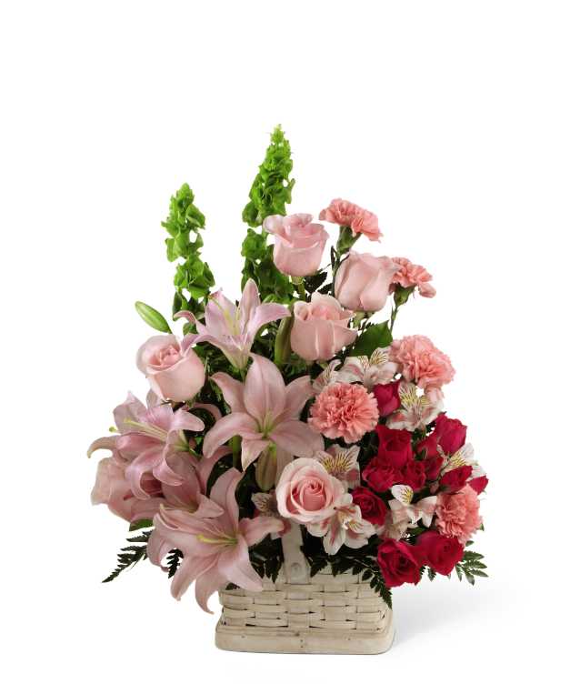 The FTD Beautiful Spirit Arrangement - The FTD Beautiful Spirit Arrangement is a light and lovely way to honor the life of the deceased. A blushing display of pink roses, Asiatic lilies and Peruvian lilies are highlighted by stems of fuchsia carnations and spray roses as well as Bells of Ireland and assorted lush greens. Seated in a white woodchip basket, this graceful arrangement creates an exceptional way to offer peace and sympathy.