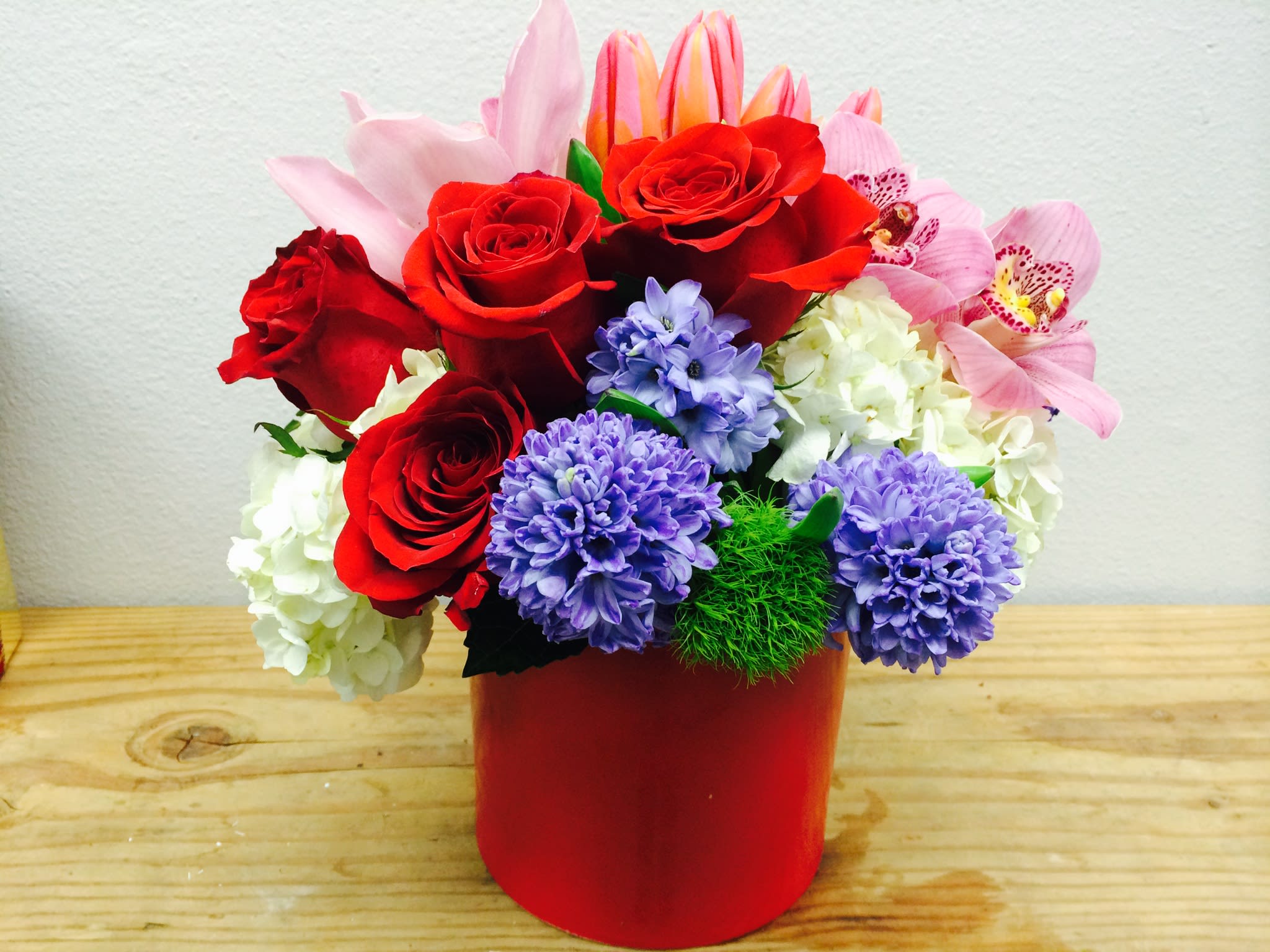 Powerful Love - A colorful mix of roses, cymbidium orchids, hydrangeas, and other blooms. 