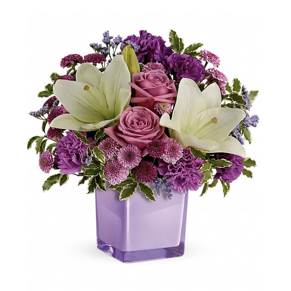 Pleasing Purple Bouquet - These luxurious lavender roses and crisp white lilies are poised to please! Perfectly presented in a stylish cube vase, it's an any-occasion surprise they'll never forget! Lavender roses, white asiatic lilies, purple carnations, lavender carnations, purple button spray chrysanthemums and lavender button spray chrysanthemums are arranged with lavender limonium and pitta negra. Delivered in a glass cube.