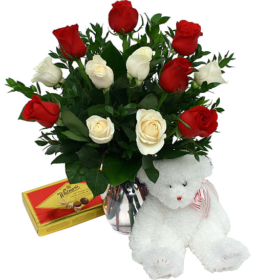 Deluxe Romance Package - A gorgeous bouquet of 12 red and white roses, arranged in a glass vase with green foliage accents and added a plush white teddy bear, plus a box of delicious chocolates. What a way to celebrate!