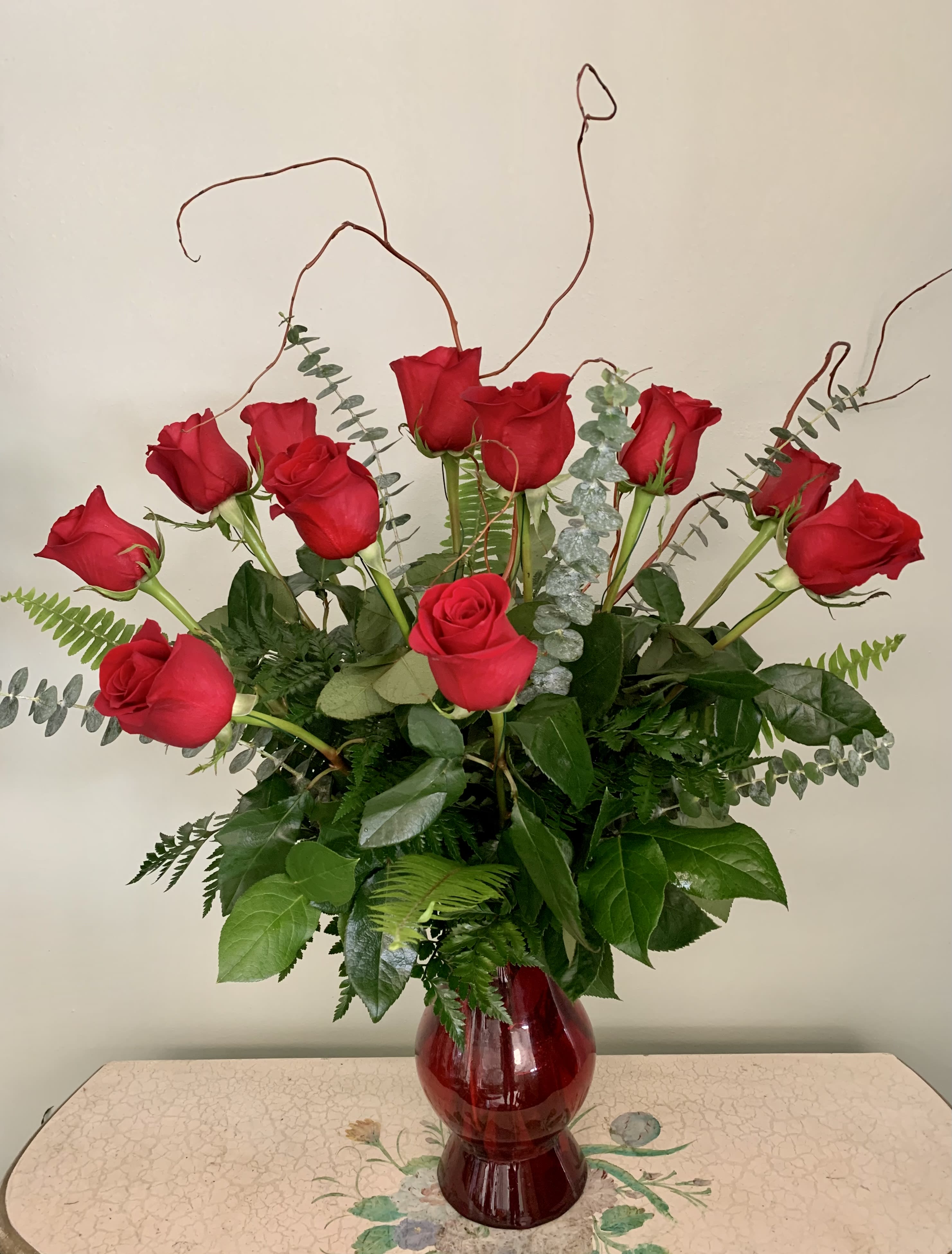 Premium Dozen Roses w/Upgraded Vase - Our most premium, long stem red roses with a stunning red vase, upgraded greenery and curly willow.   