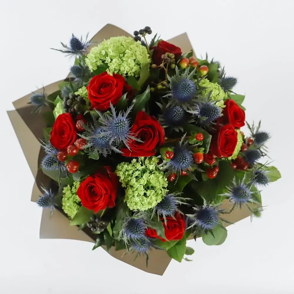 Love Struck - Hand Tied Arrangement without Vase, with romance comes passion, with passion comes fury. This bitter, sweet selection of velvet, Grand Prix red roses and prickly, blue thistle is the perfect 'Capulet and Montague' bouquet.