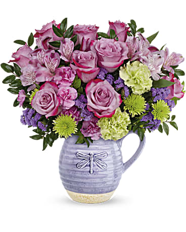 Teleflora's Whimsical Dragonfly Bouquet - Pour on the love with this wonderfully whimsical Mother's Day gift! Bursting with a colorful bouquet, this glazed ceramic pitcher is as practical as it is charming--it's food-safe so mom can enjoy it on her breakfast table for years to come! Lavender roses, green carnations, purple sinuata statice, lavender alstroemeria, green cushion spray chrysanthemums and miniature lavender carnations are arranged with huckleberry. Delivered in Teleflora's Whimsical Dragonfly pitcher. Orientation: All-Around 
