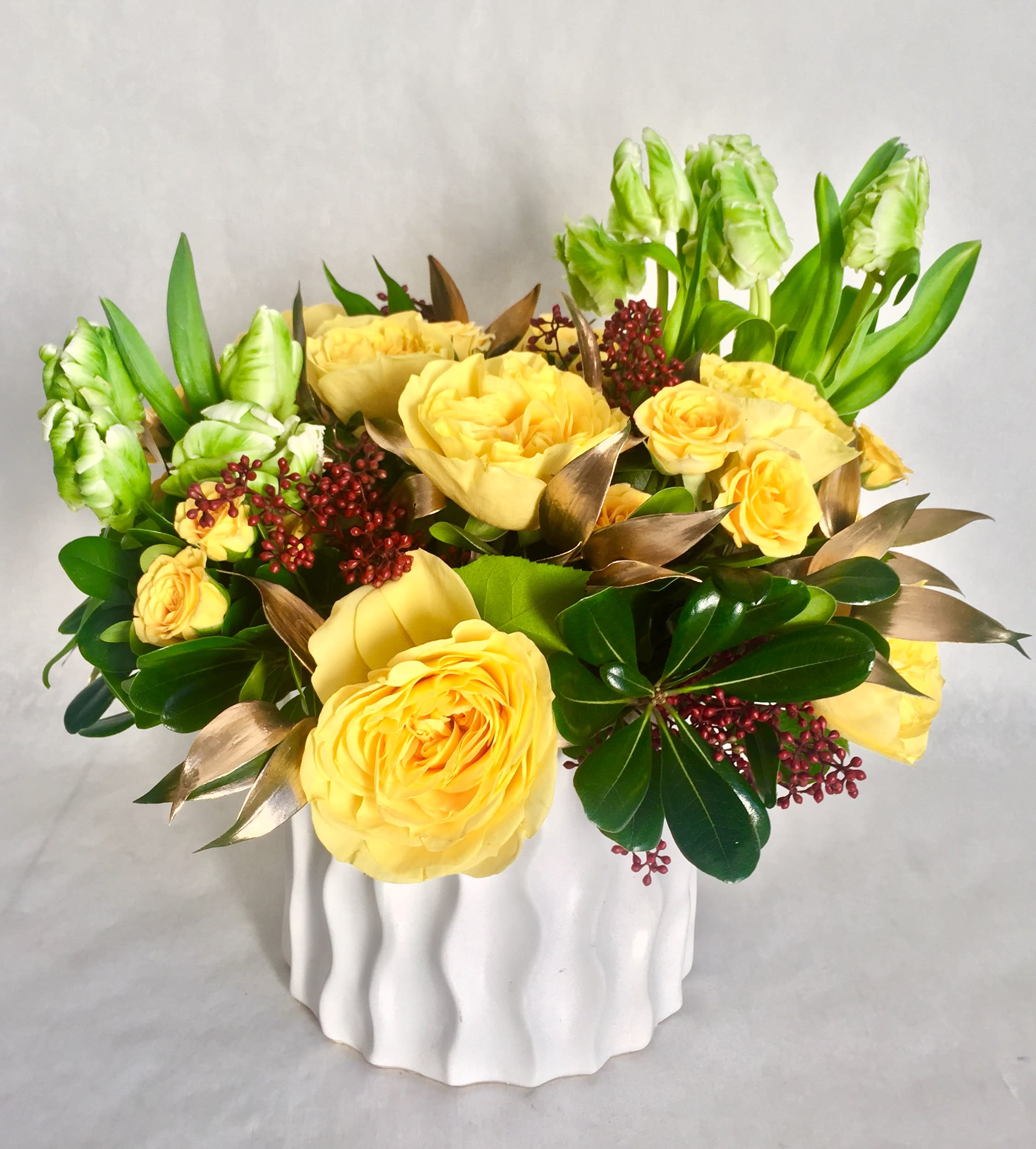 Spring Sunshine - This is a perfect gift to bring sunshine and joy to your loved ones during this winter season. Arrangement include parrot tulips and English garden roses. Accent with hand painted gold foliage. Beautifully arranged in a modern white porcelain vase. This arrangement is approximately 13&quot; Round.