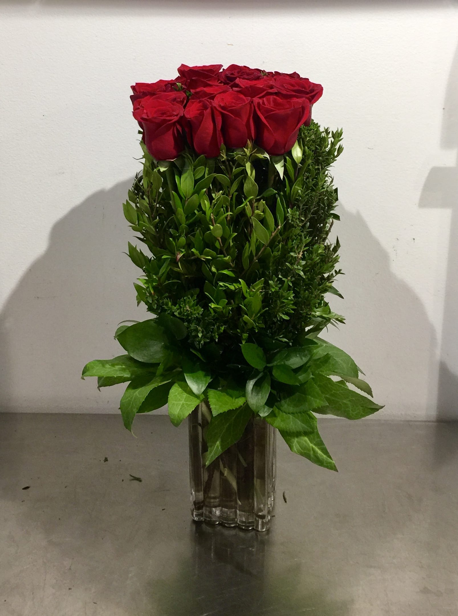 Red Rose Hedge - Custom vase arrangement of red roses designed in the style of a hedge with choice greens  *Regular is 1 dozen roses *Deluxe is 2 dozen roses *Premium is 3 dozen roses