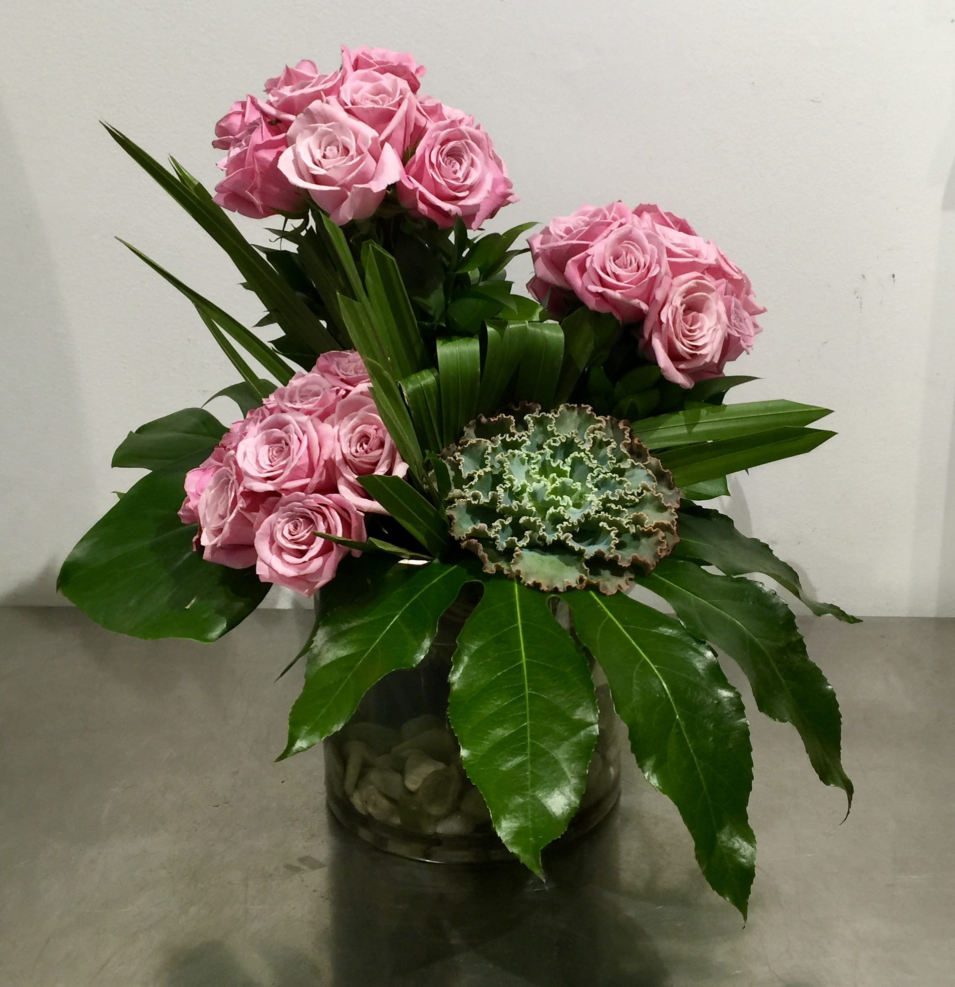 Lavender Trio - Custom arrangement of lavender roses with succulent in clear glass vase with stones.