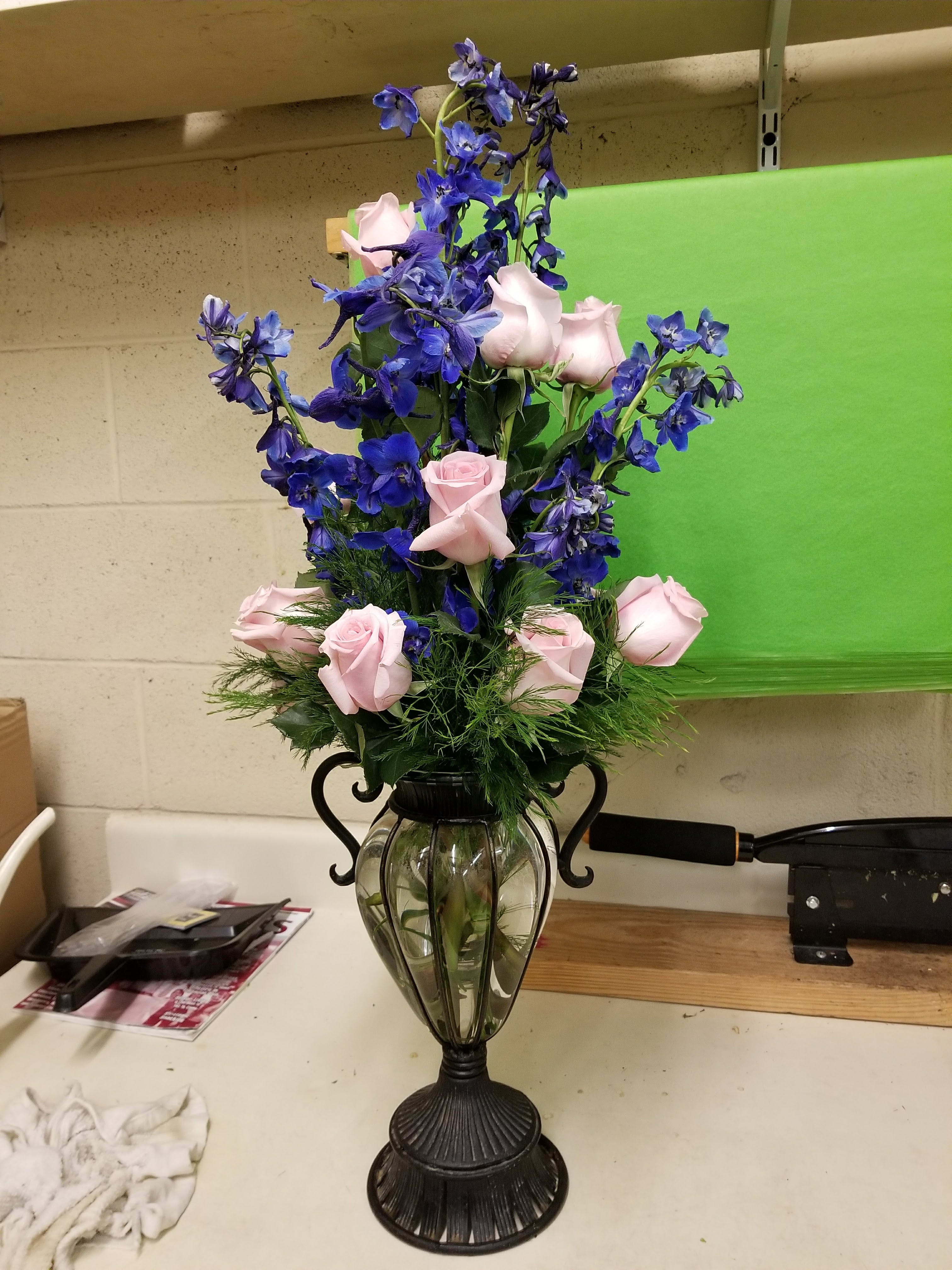 Blues and pinks - 12 light pink roses and 9 blue delphinium. Vase will vary.