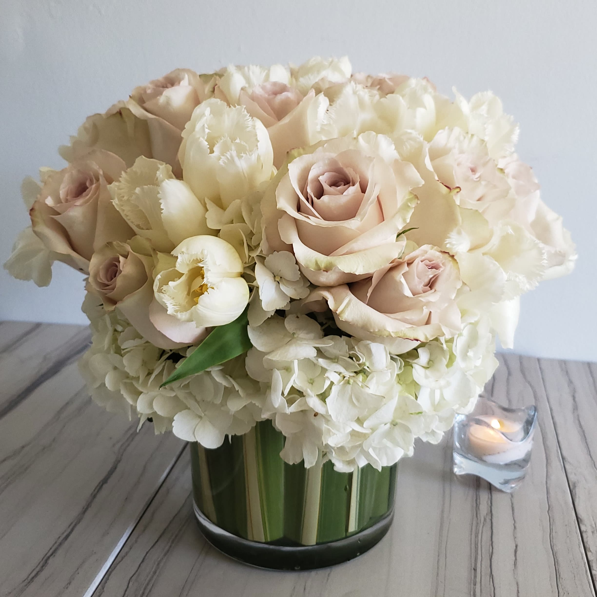 Cream and white classic  - Cream Roses and white tulips in a glass vase accented with some hydrangeas. 