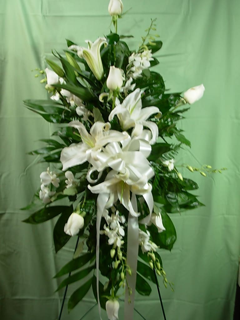 ROSES and ORCHIDS STANDING SPRAY  NEW-S46 - Our ROSE and ORCHIDS STANDING SPRAY is made of all white flowers featuring roses, oriental lilies and orchids with white ribbon bow and cascading ribbon streamers..  