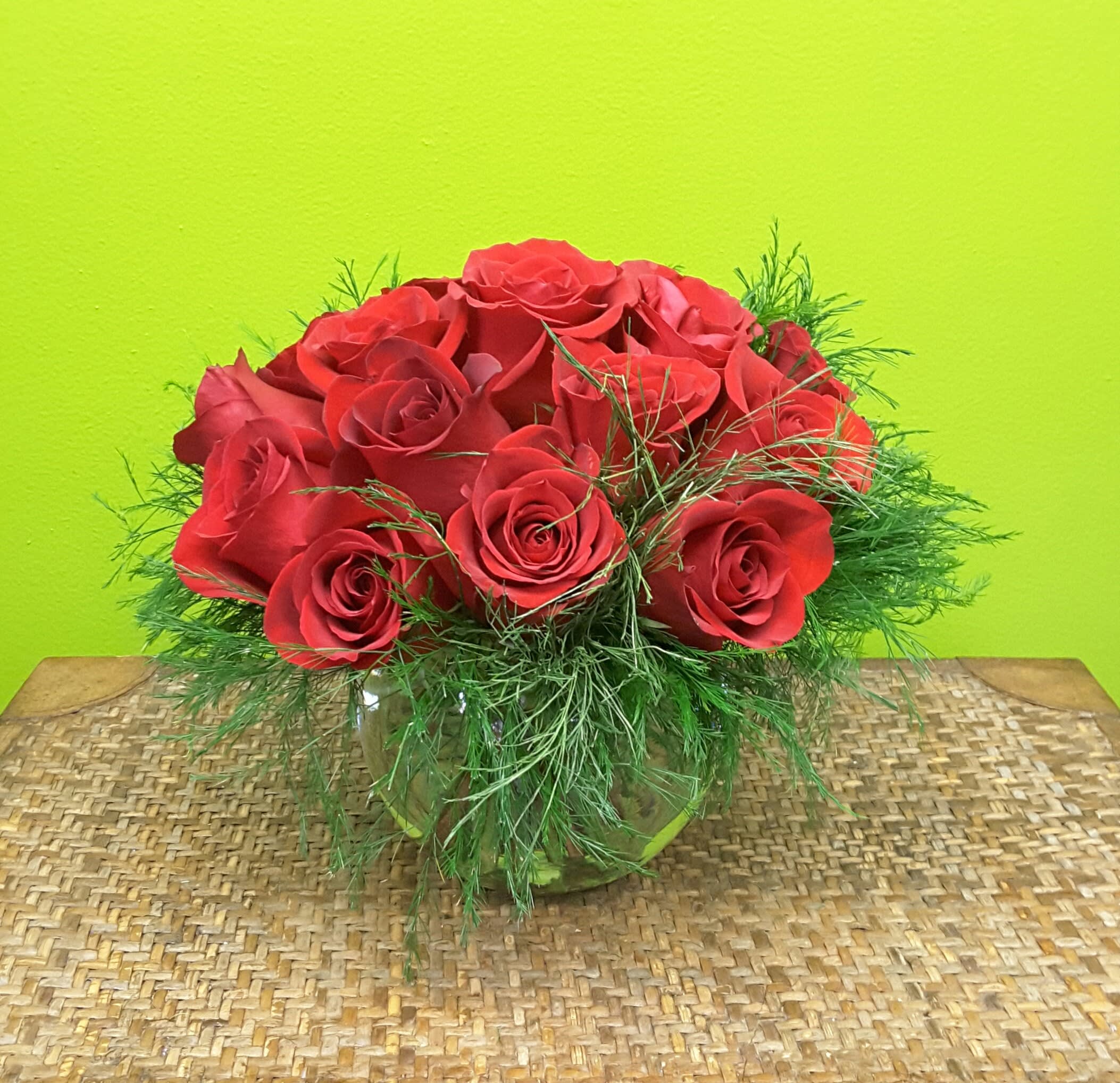 MODERN ROSES  NEW-A38 - Our MODERN ROSE arrangement  is a dozen roses stylishly arranged,low and compact in a round bubble ball container with greens  for that modern look .. Great for a coffee table, side table or any location were a dramatic , modern floral accent is needed.. For larger arrangements , similar in style , please phone us at 1-800-331-5358 for your special needs. 