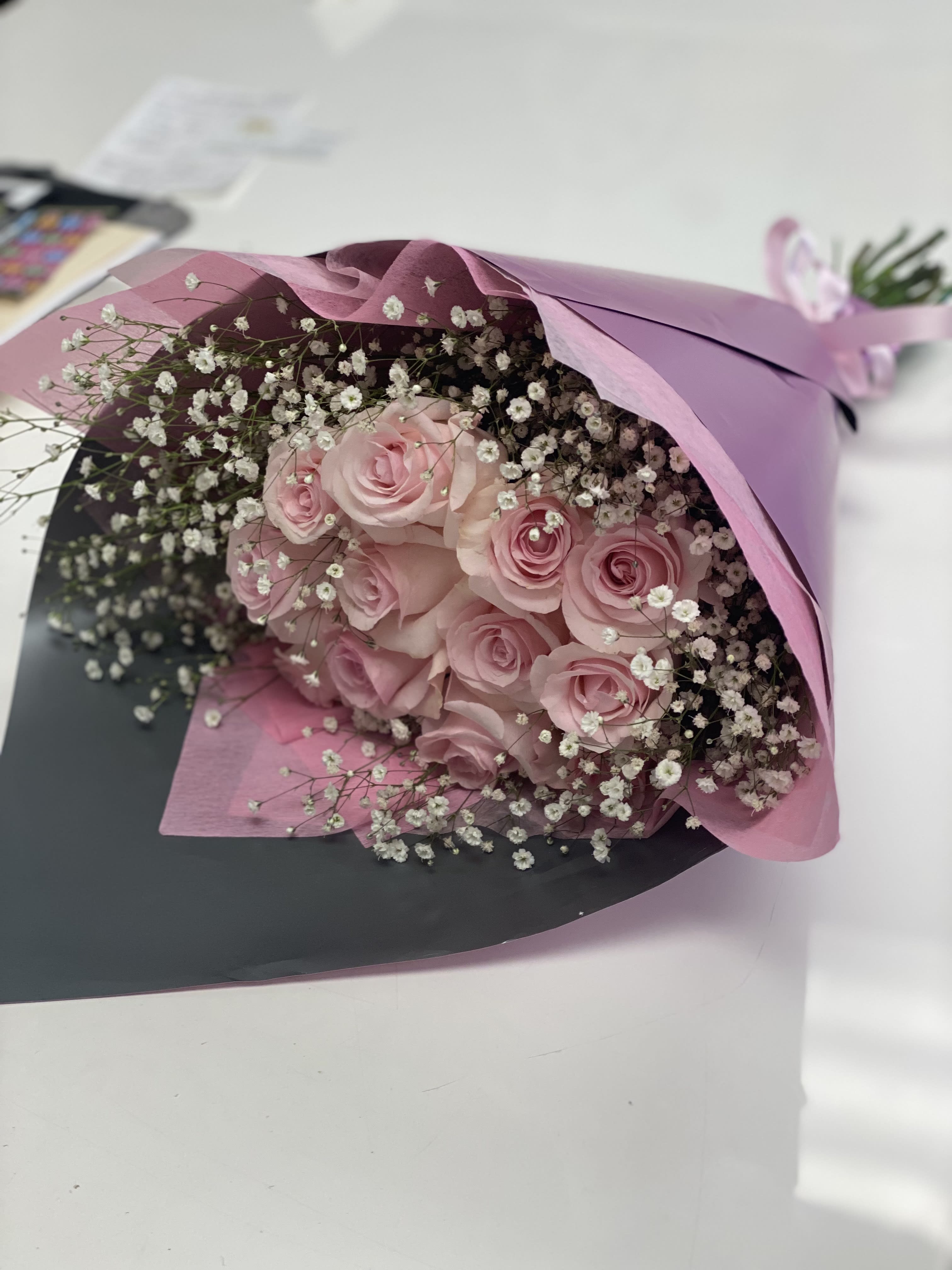 Pink Makes it all nice - 1 Doz Pink Roses , baby’s breath wrapped in specialty tissue