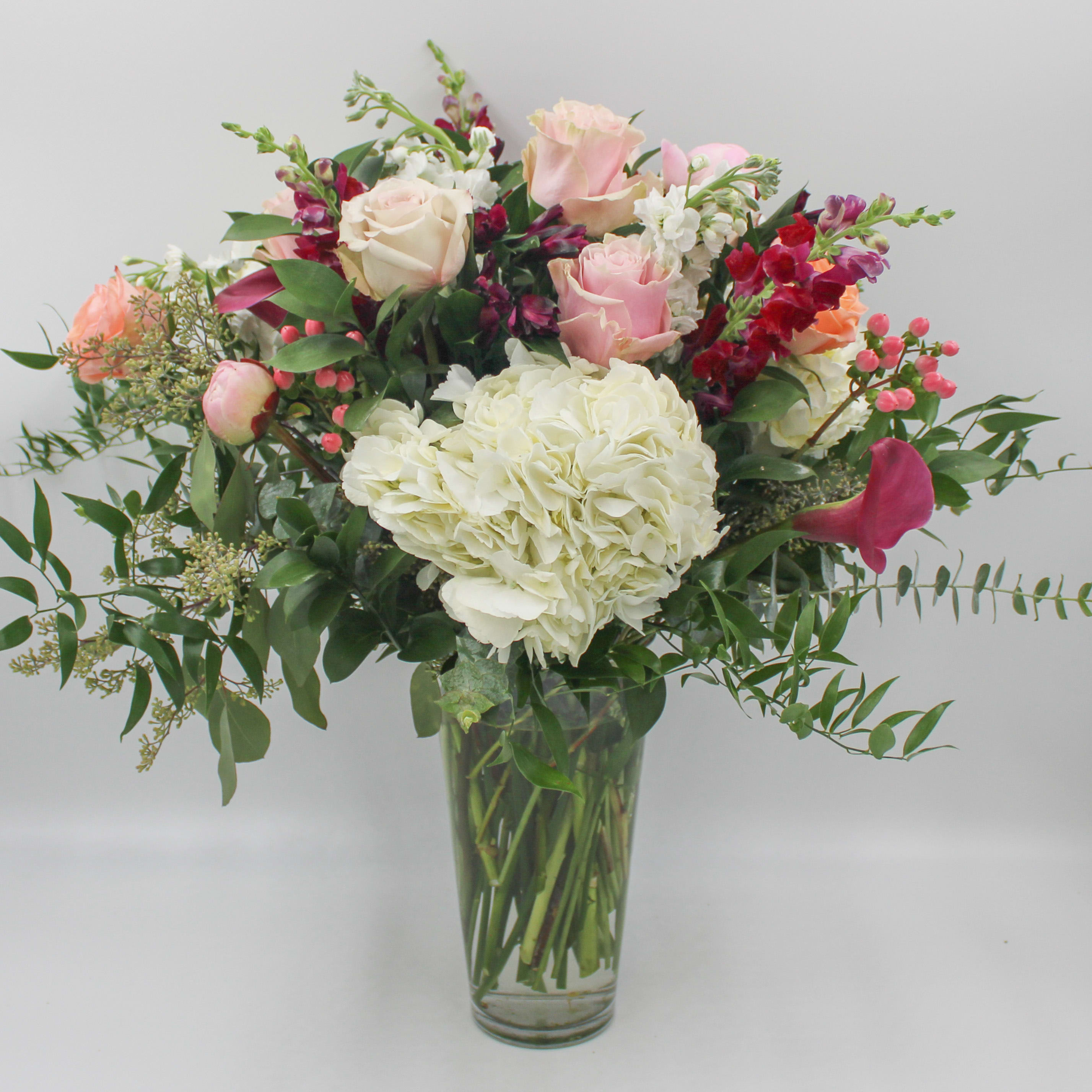 Napa Valley - Napa Valley features White Hydrangea, Light Pink Roses, Quicksand Roses, Peach Roses, Pink Hypericum Berries, Burgundy Calla Lilies, Burgundy Snapdragon, White Stock, Purple Alstromeria, Italian Ruscus, Seeded Eucalyptus and Spiral Eucalyptus. 