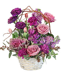 Purple Showers - There's nothing quite like the feeling of a tranquil Spring day to boost their spirits. Take your favorite person on a luxurious trip through an English garden and nurture their sweet side with this basket full of purple flowers including roses lisianthus carnations and pink tulips.