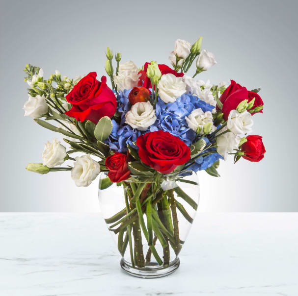 American Girl by BloomNation™ American Girl by BloomNation™ - Red, white and blue is a classic combo. Send a thank you present after being invited to a bbq on Memorial Day weekend, Labor Day, Fourth of July or just send a gift to your patriotic friend. APPROXIMATE DIMENSIONS 14" W X 14" H