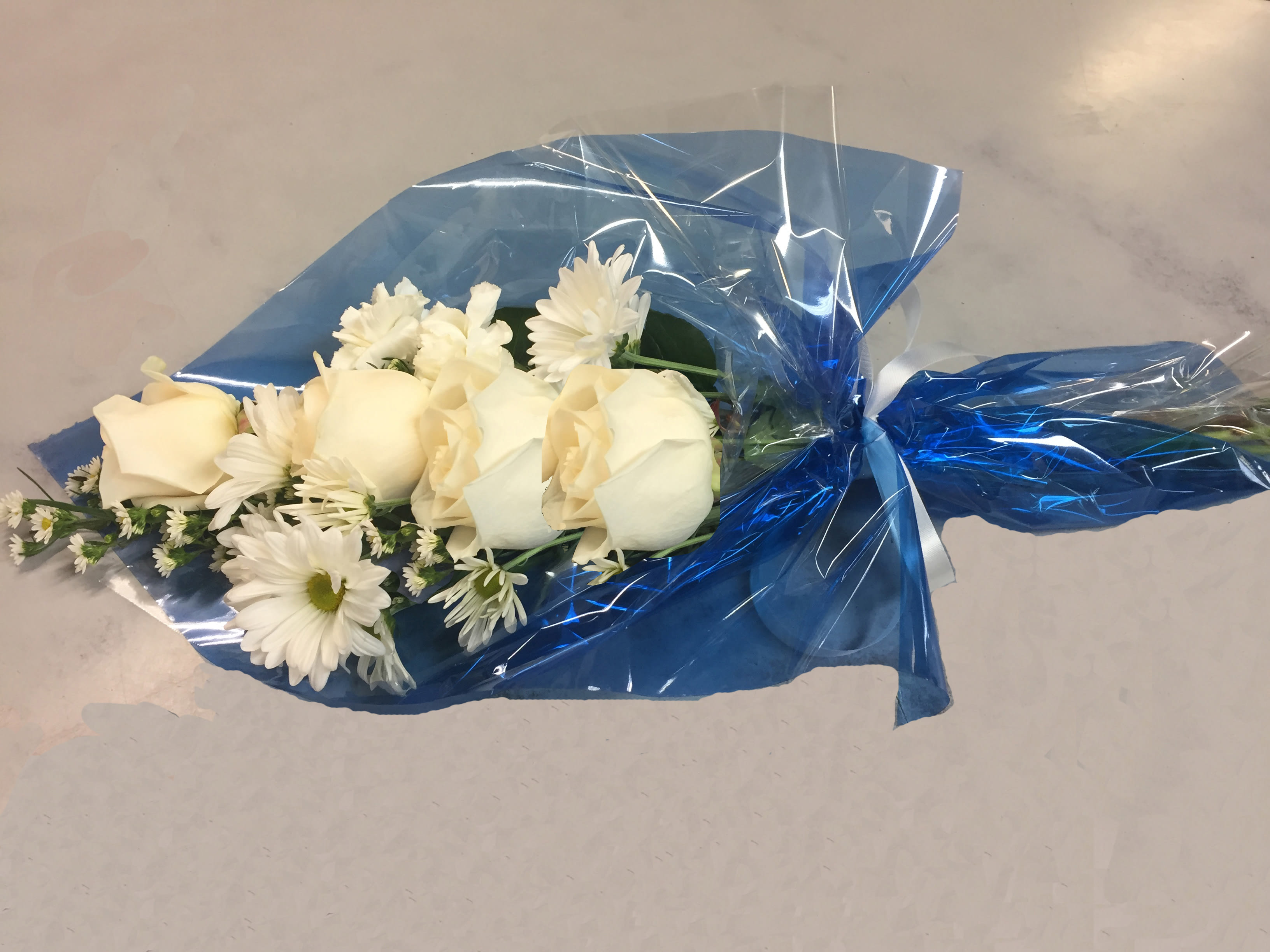 Simple Blue and White Wrap - Roses, daisies, carnations and Montecasino accented with greens, blue cellophane wrap and ribbon.