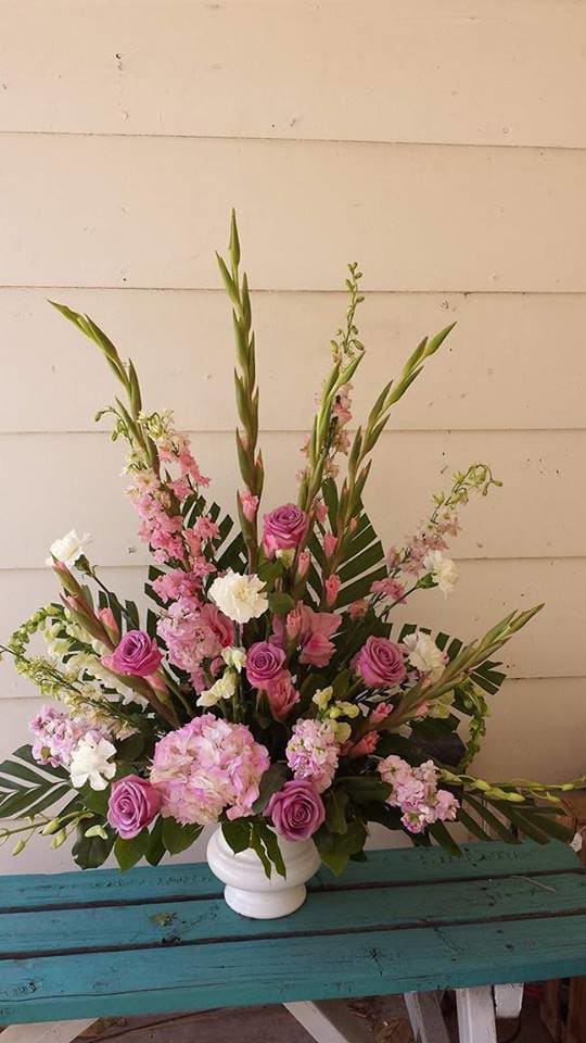 Soft Memories - White urn with Pink Glads,Larkspur, Hydrangea, stock, lavender Roses, white carnations. Soft mix of color
