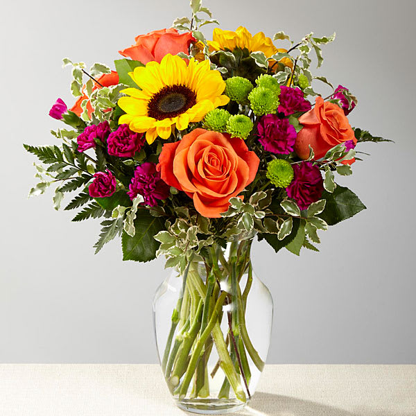 The Color Craze Bouquet The Color Craze Bouquet - The Color Craze™ Bouquet blooms with a vibrant energy to create a special moment for your recipient! Our floral professionals weave together a blend of orange roses sunflowers violet mini carnations green button poms and lush greens to create an incredible gift. Presented in a clear glass vase this truly colorful display of fresh flowers is ready to send your warmest birthday thank you or get well wishes straight to their door.
