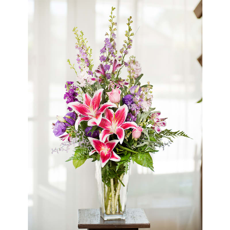 Stargazing Blooms**** - Item Code: 117-VF The Stargazing Blooms bouquet is the perfect feminine design.  The glass vase contains a mixture of  purple and pink flowers such as larkspur, roses, alstroemeria, stock, lisianthus, stargazers, and caspia filler.    approx. 30&quot;h x 14&quot;w